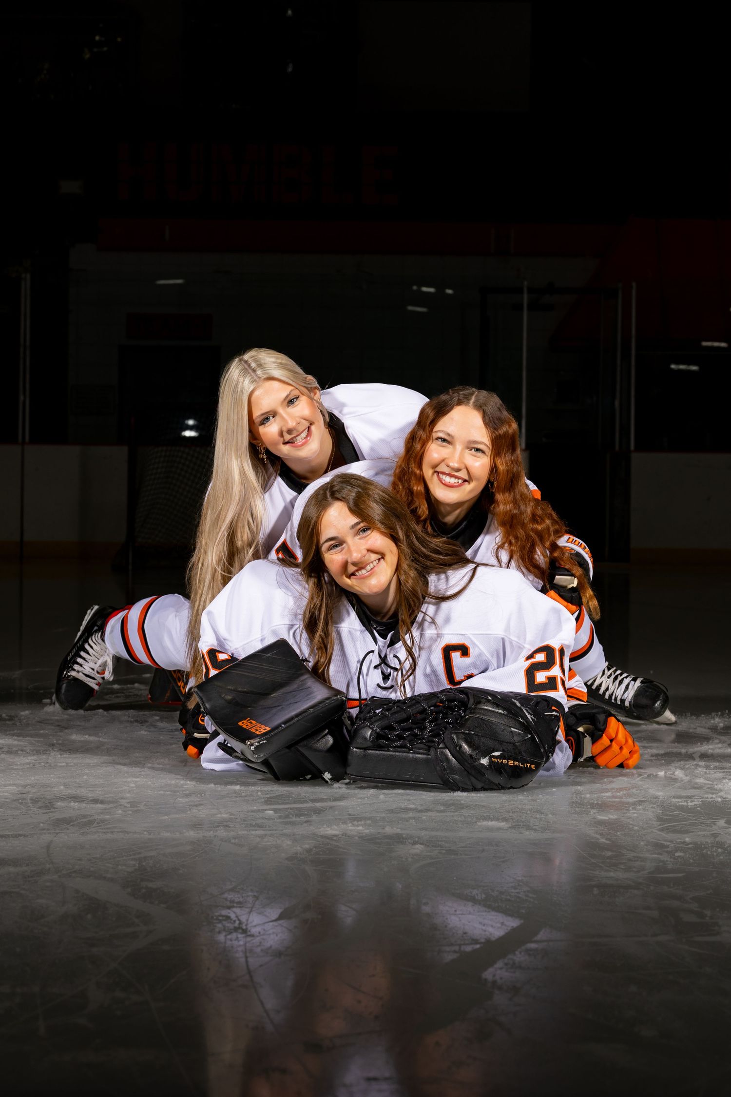 Farmington Tigers girls hockey seniors pile on each other for a group media day photo