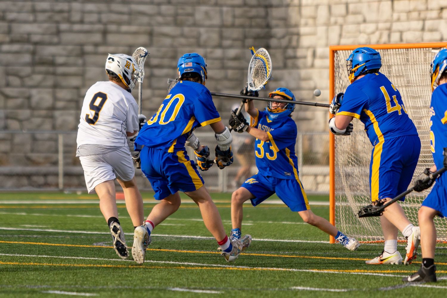 Rosemount Irish lacrosse player dodges a defender to take a shot on goal