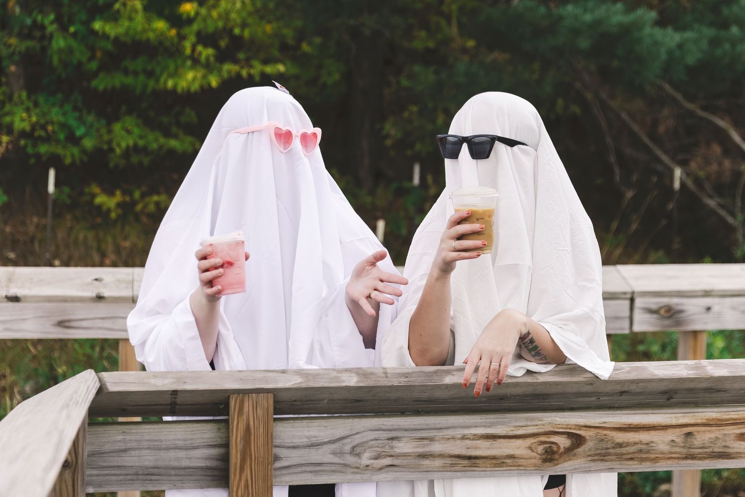 Two friends dressed as ghosts enjoying a coffee and chatting about their day at Carver Lake Park in Woodbury MN