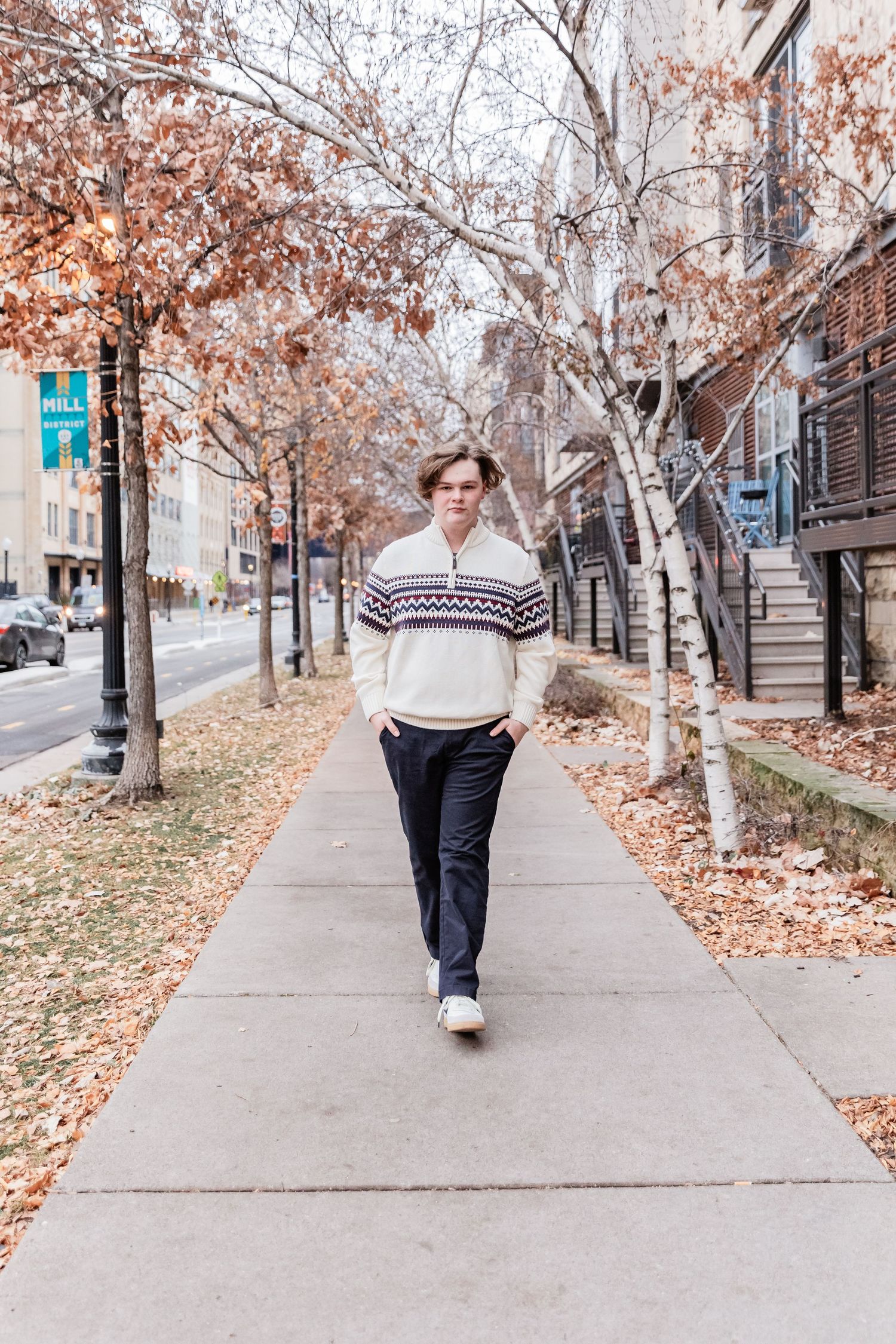 Elliott casually strolls down sidewalk near Mill Ruins Park as the fall leaves swirl behind him