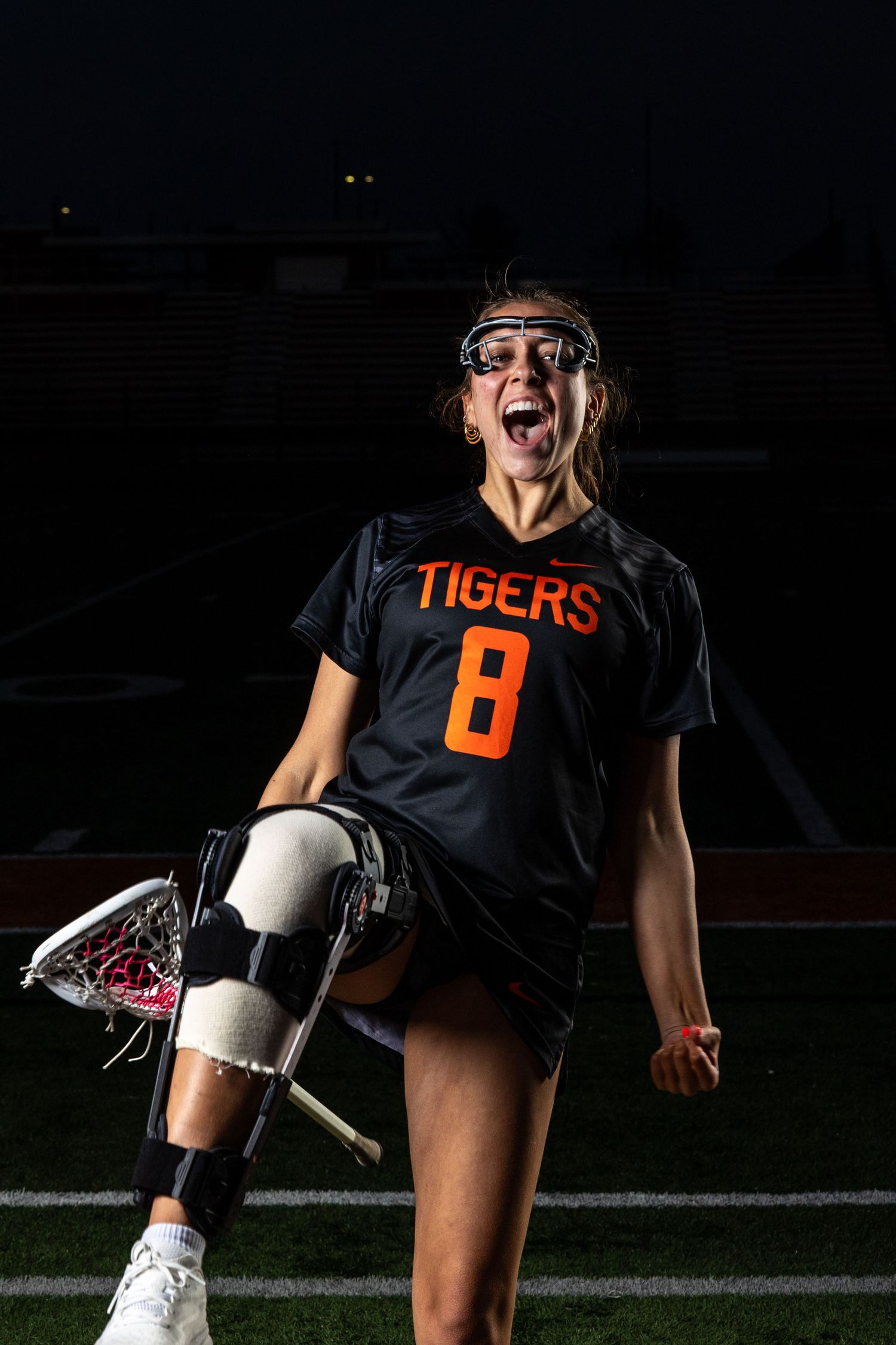 Farmington Tigers girls lacrosse player gives her best kick up and scream pose for media day pose