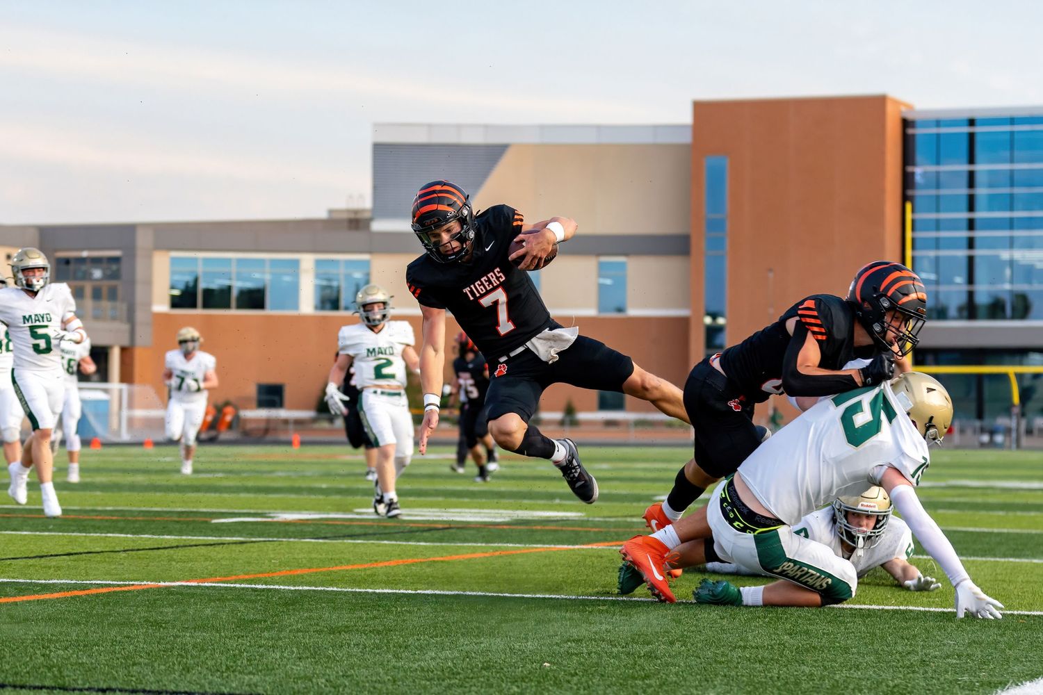 Farmington Tigers quarterback Jonah Ask hurdles over the defense for a touchdown