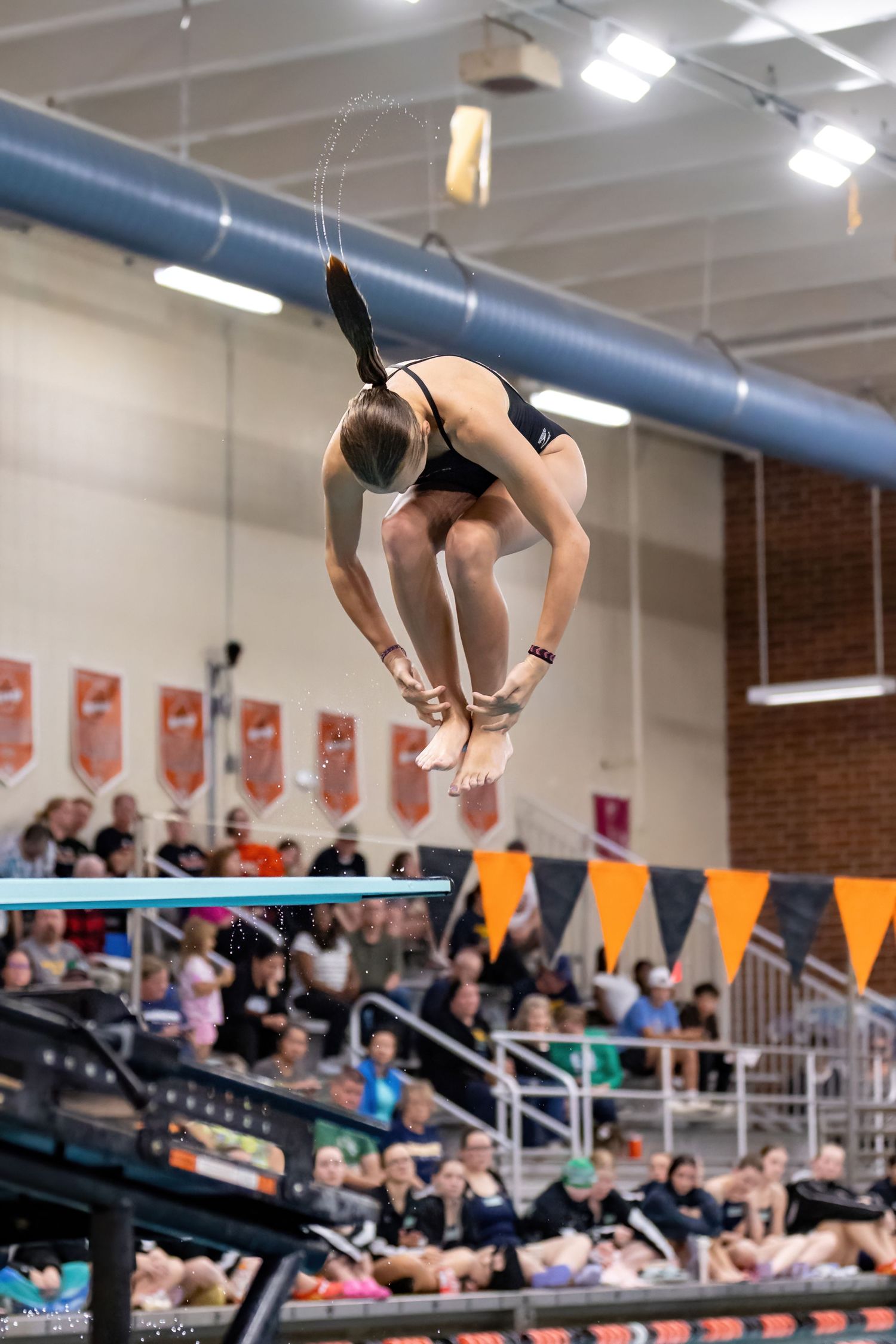 Farmington Tigers girls diver mid spin as she goes for the top score