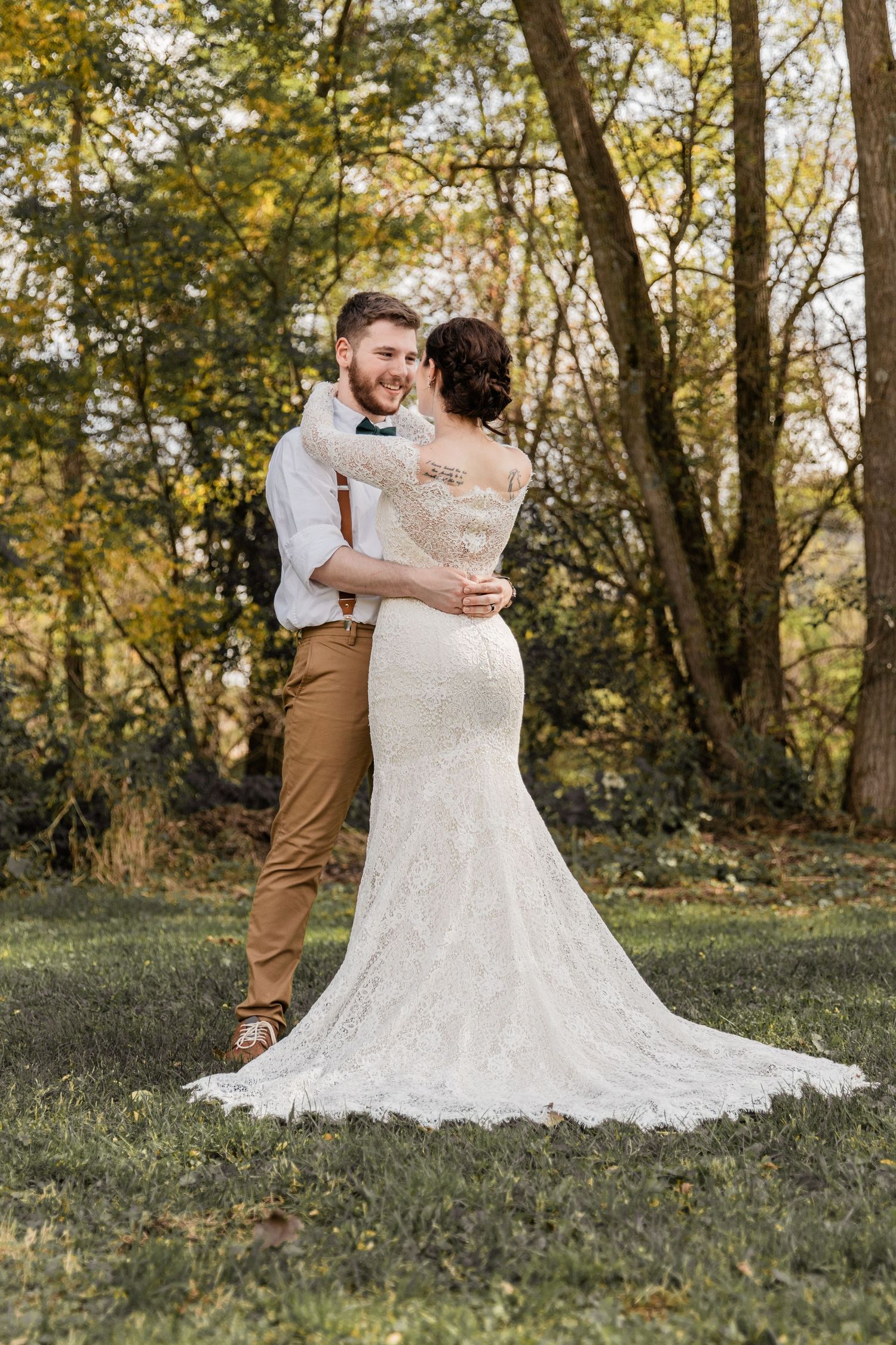 groom smiles at his bride in a scenic outdoor venue on a fall day