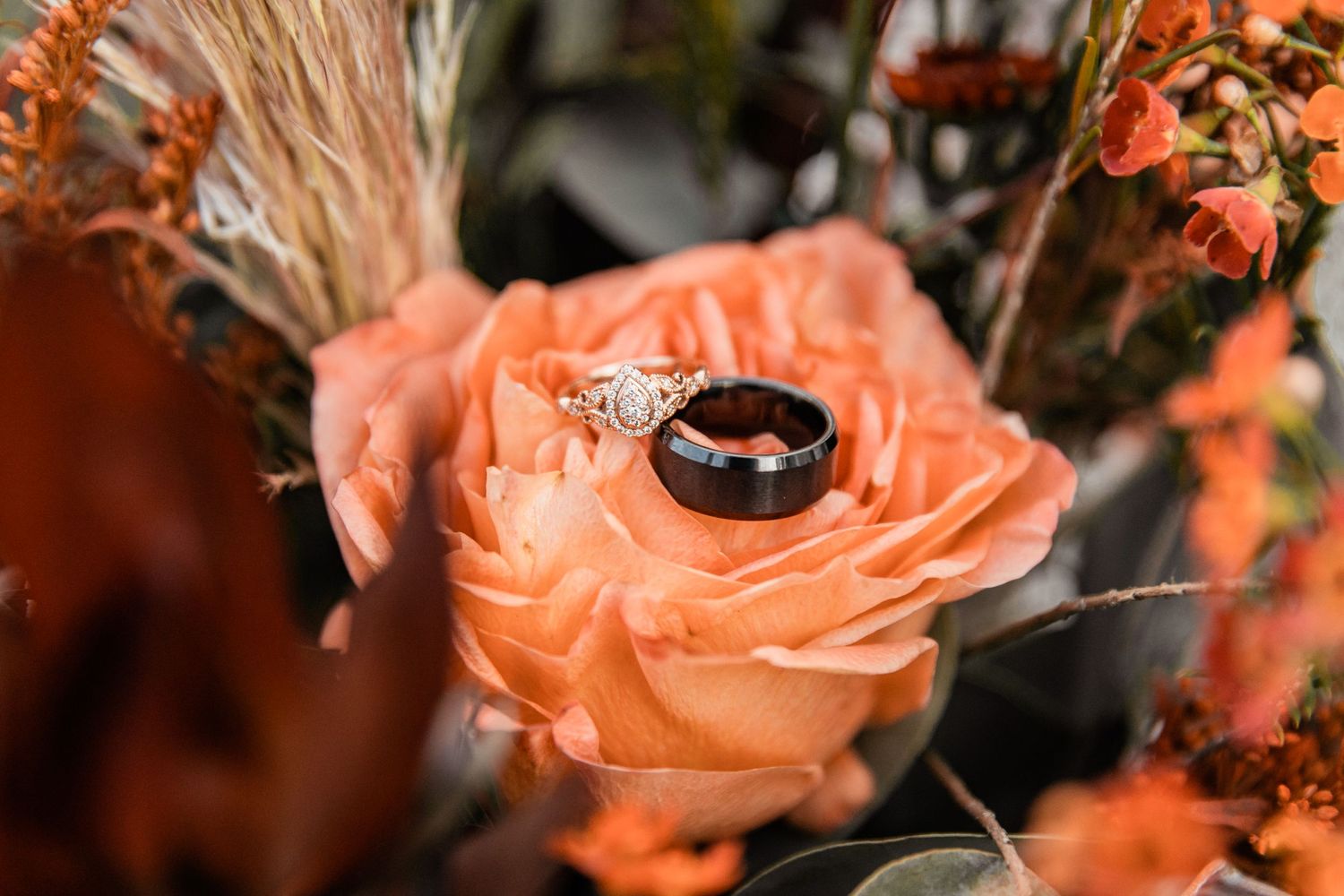 bride and groom rings on bride's flower arrangement