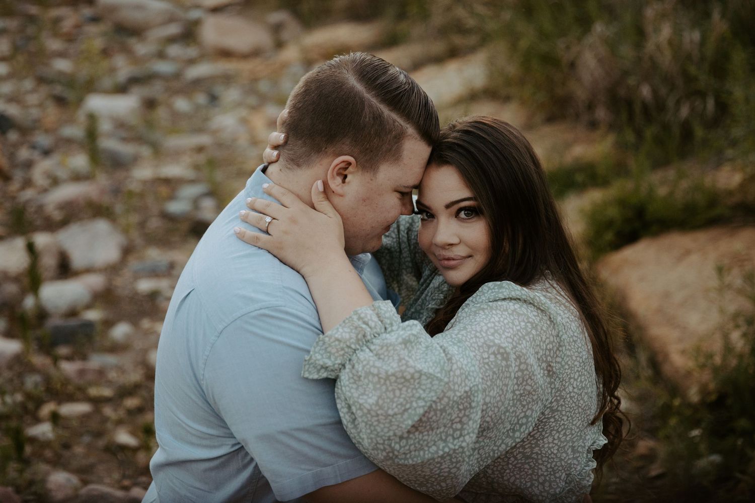 loving woman embraces her fiance in a river bed