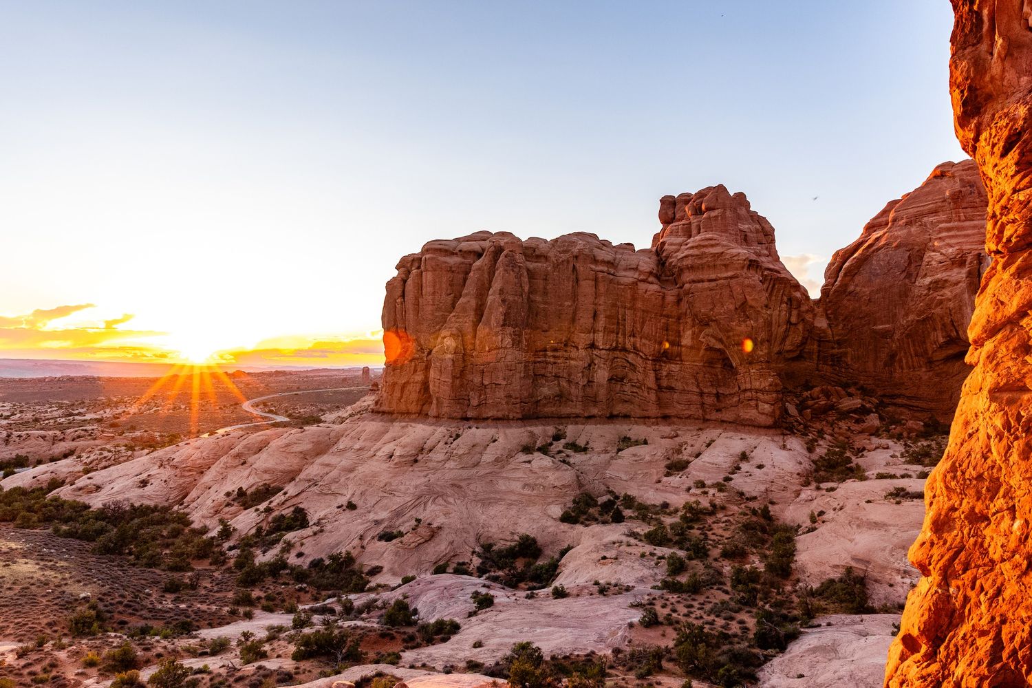 Arches National Park with a sun flare hitting the lens at sunset in the summer
