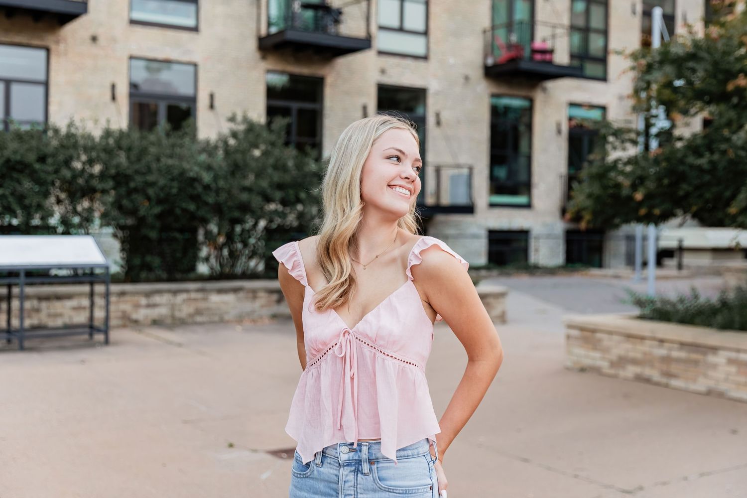 Lucy casually looks over her shoulder as she stands in the plaza of a Minneapolis apartment complex by Stone Arch Bridge