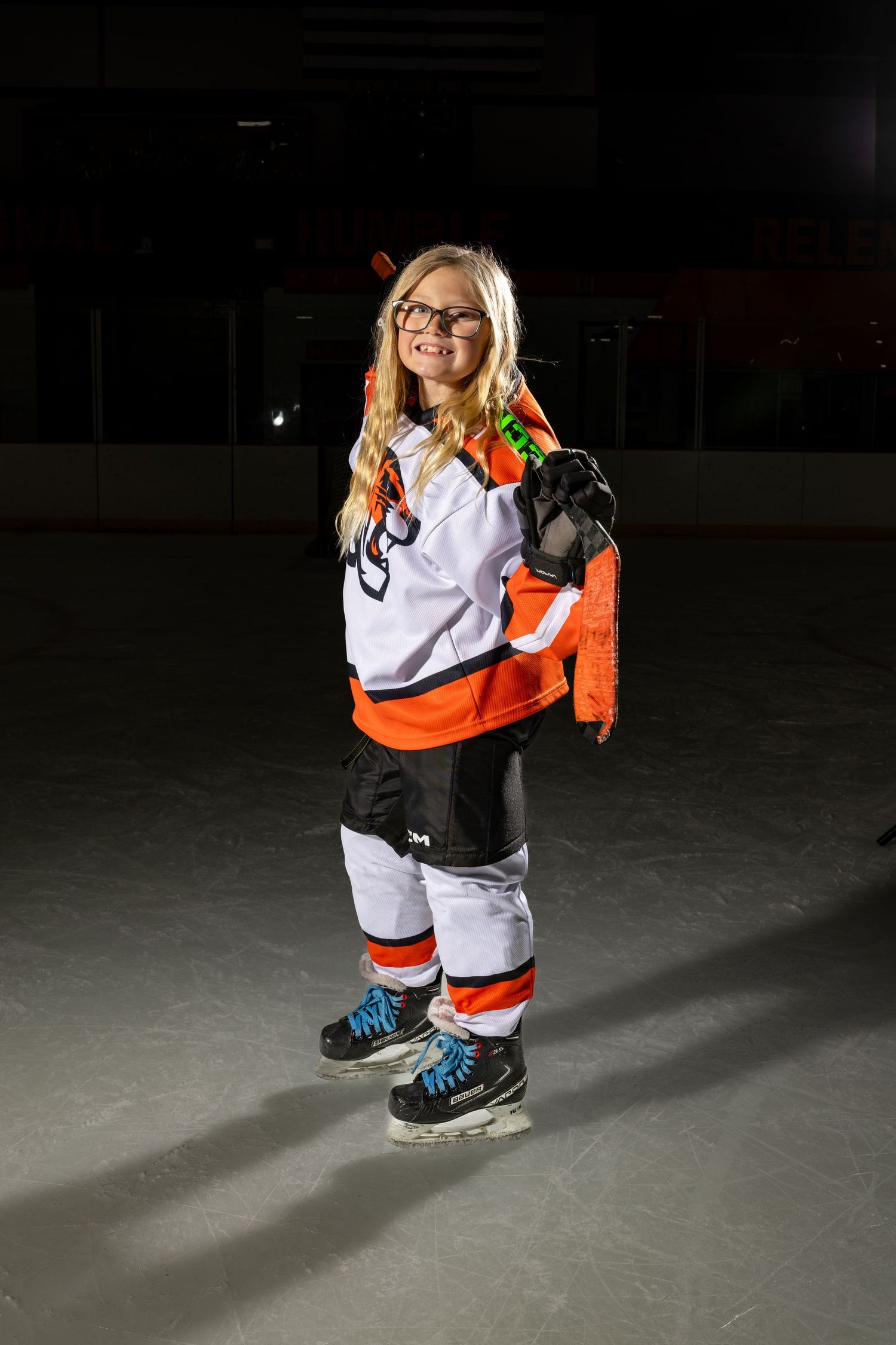 Farmington Tigers girls youth hockey player poses with her stick across her shoulders
