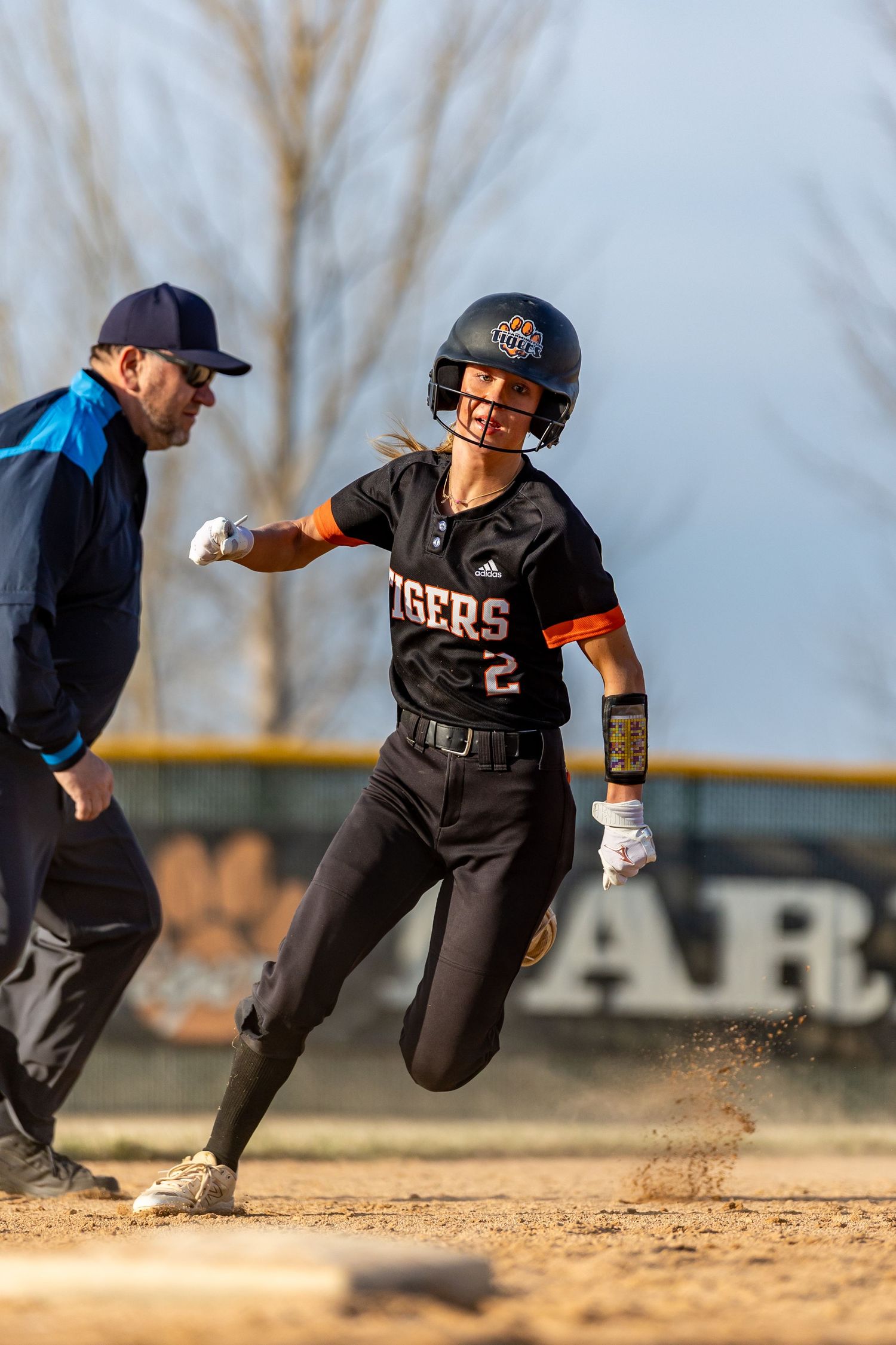 Farmington Tigers softball player rounding third base to score a run