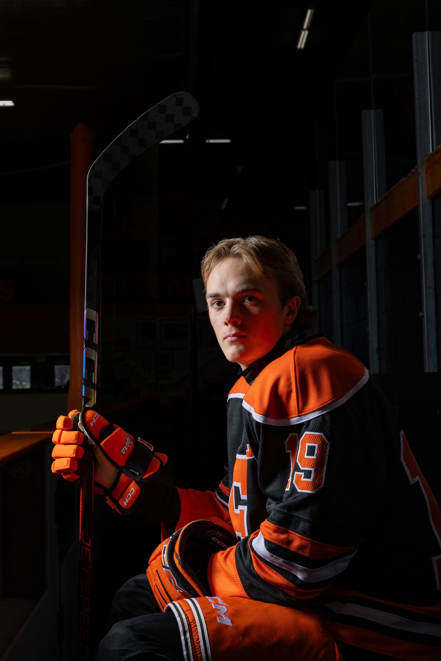 Farmington Tigers boys hockey senior player stares into the camera on the bench for media day