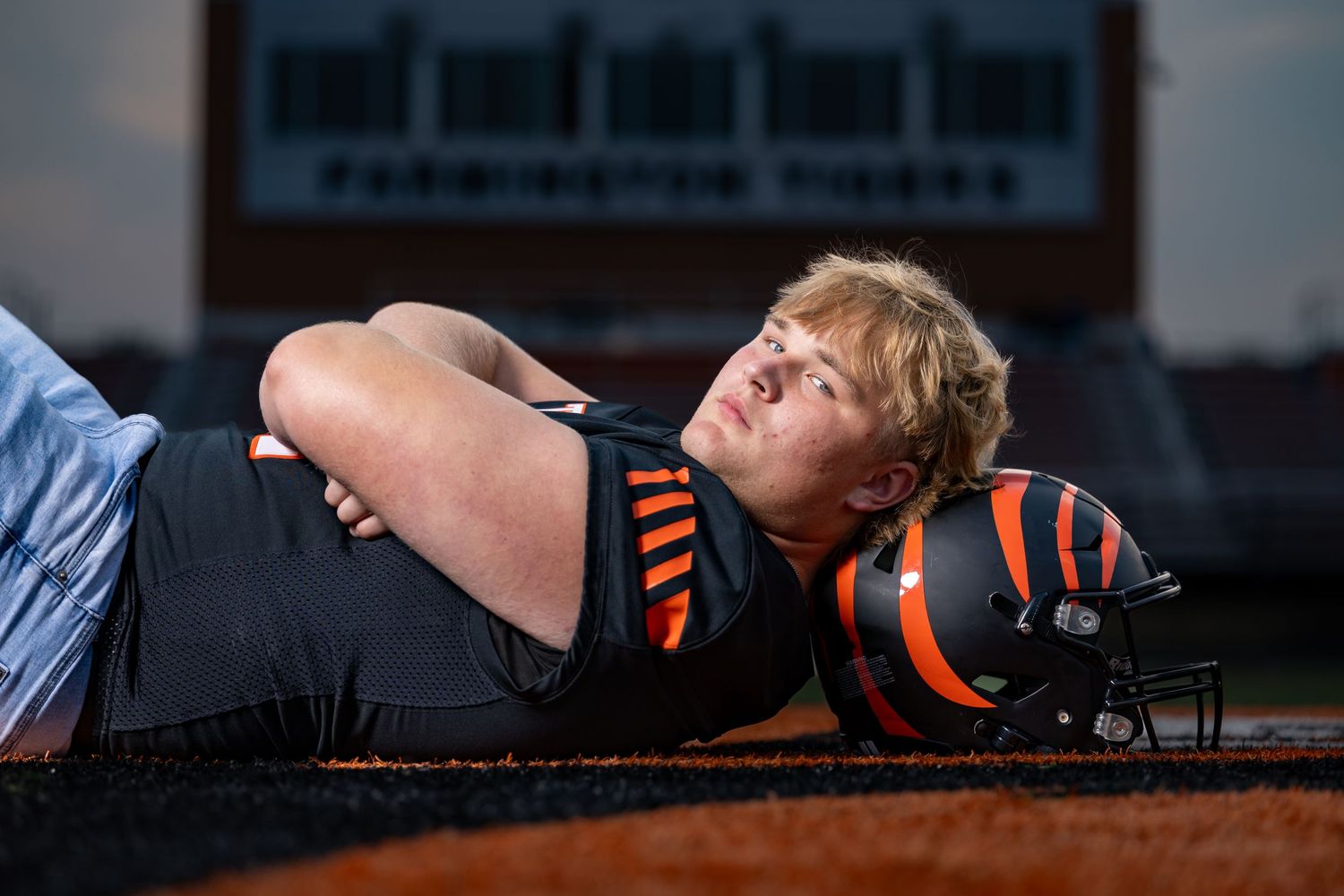 Isaac lays down at center field with is head resting on his hemet with his arms folded across his chest