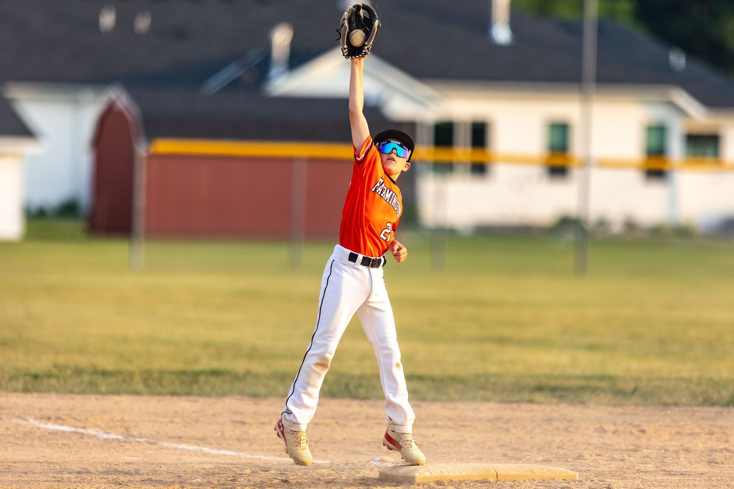 Youth baseball player jumps up to make the catch