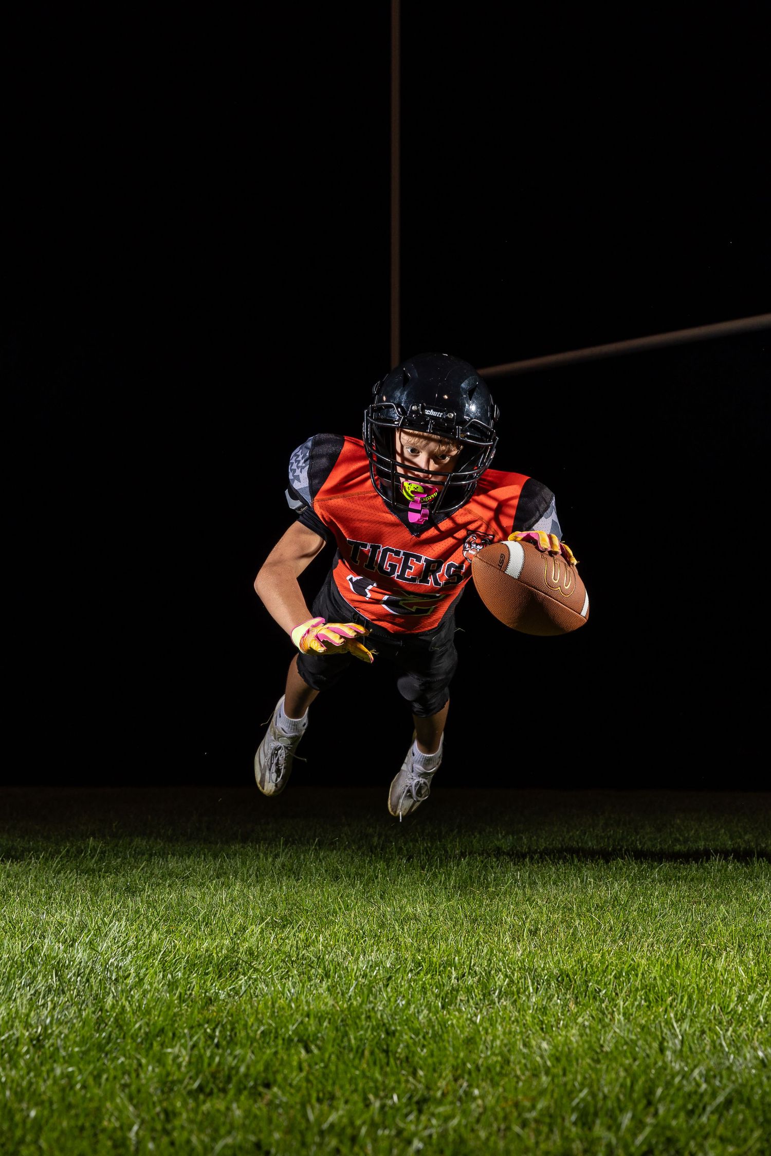 Farmington Tigers youth football player dynamic lighting sportrait twin cities sports photographer Henry Christensen