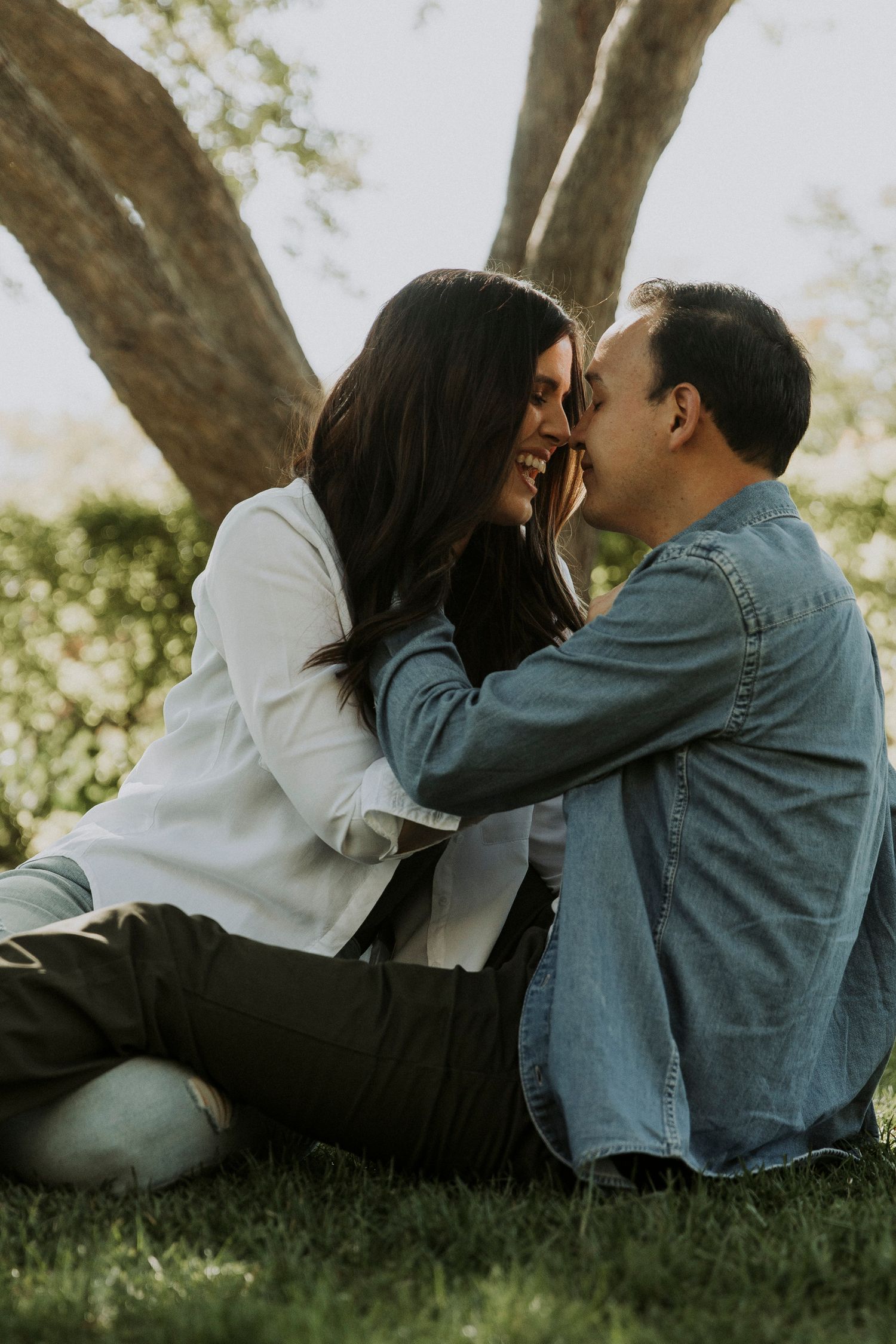 Engaged couple lean into each other for a passionate kiss