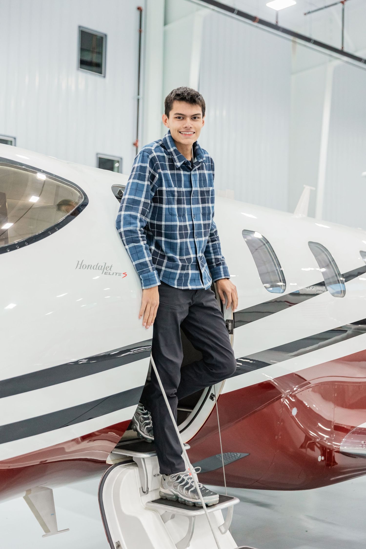 Aspiring aviation mechanic climbs down Gulf Stream jet staircase in Lakeville for his senior photos