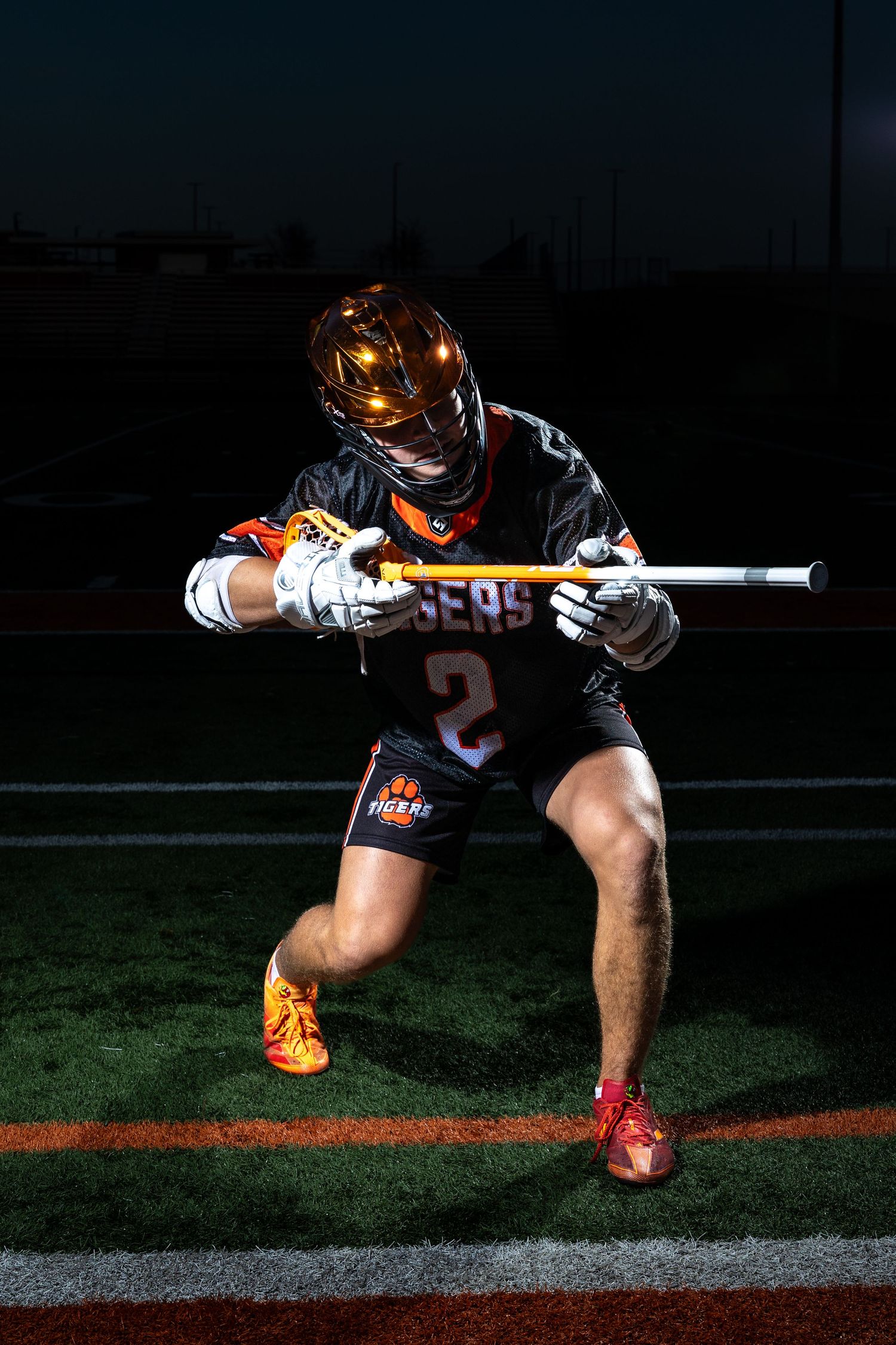 Farmington Tigers boys lacrosse player pretends to take aim at the opponent for media day pose