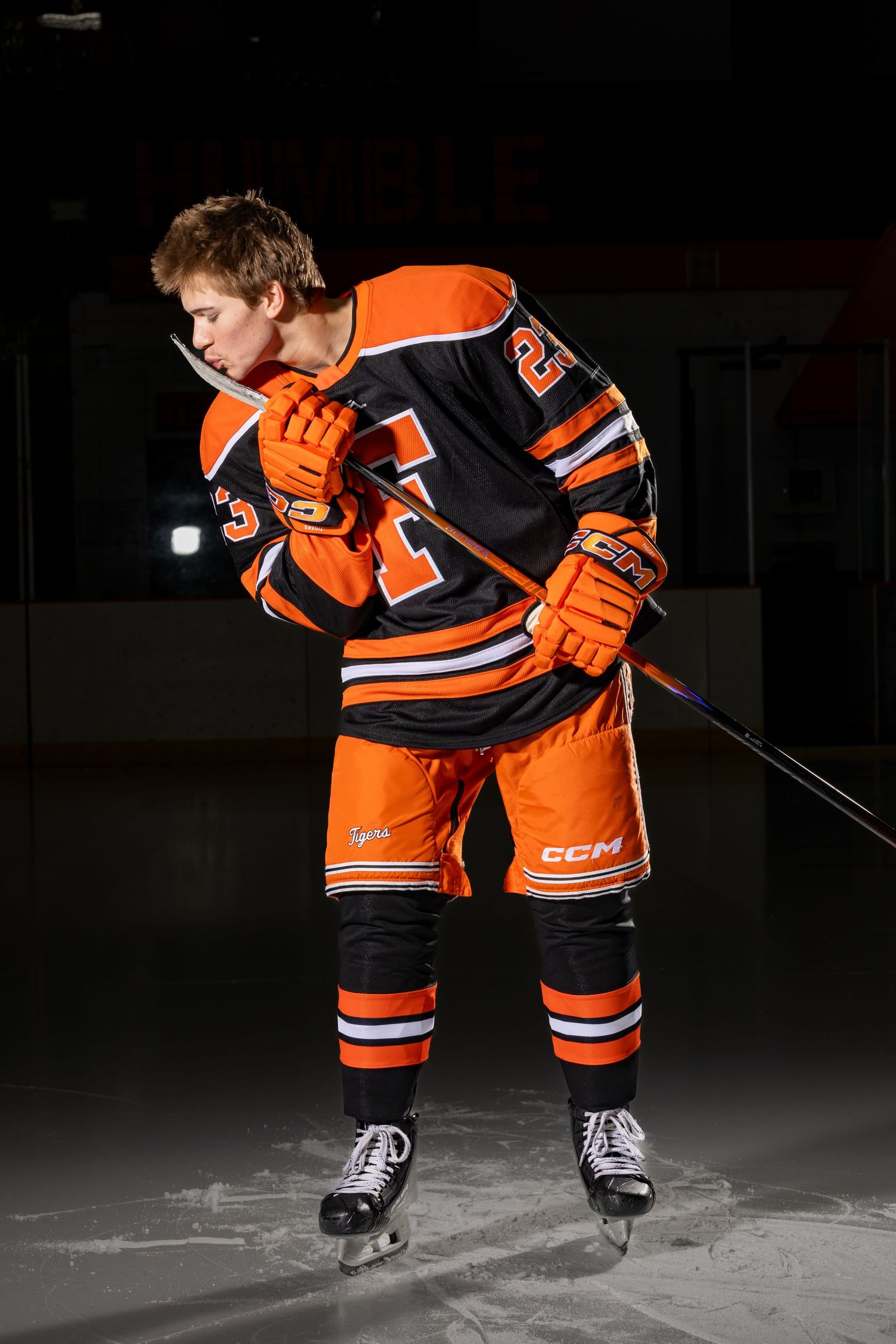 Farmington Tigers boys hockey player kisses his stick for his goal celebration pose for media day