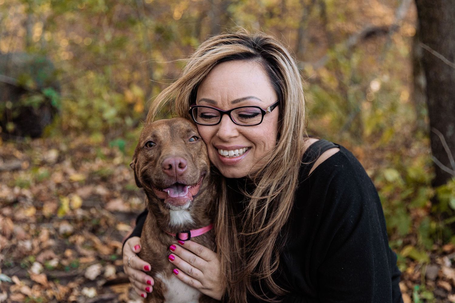 Single woman gives her puppy a big hug and smiles