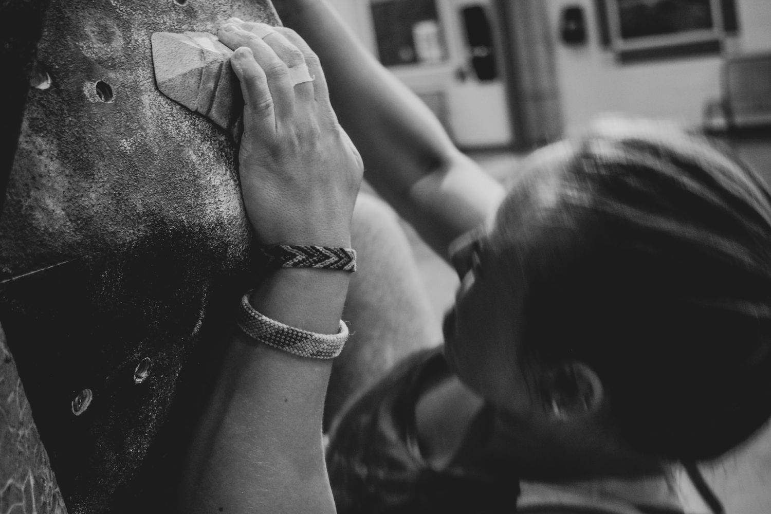 Close-up of climber's hand gripping a hold on an indoor climbing wall.