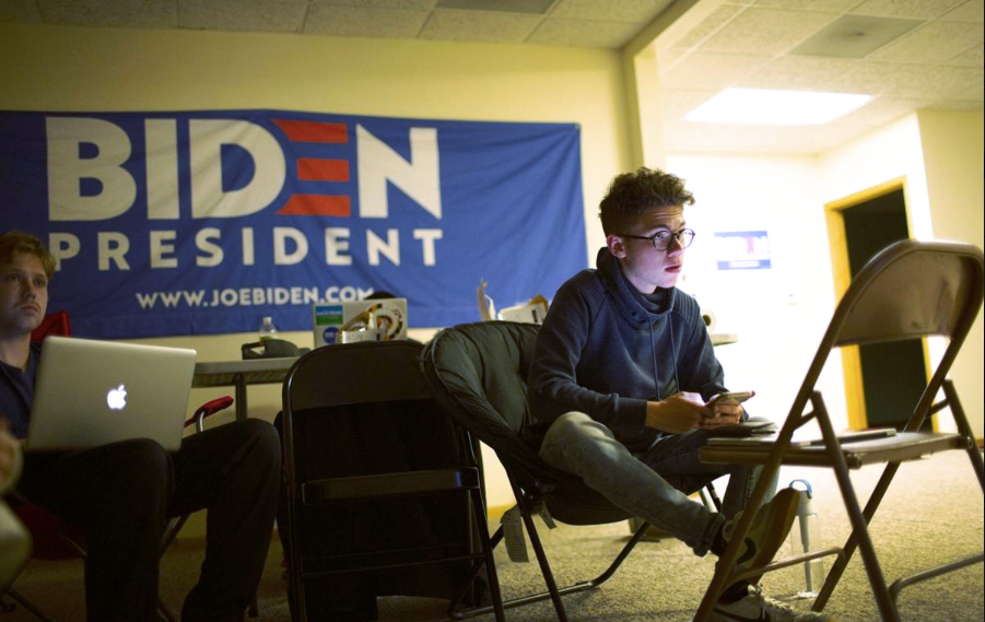 Campaign office interior with Biden for President banner visible in background.