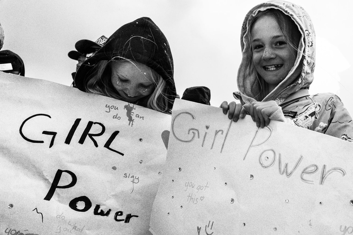 Two young girls holding Girl Power signs at a rally in black and white photo.
