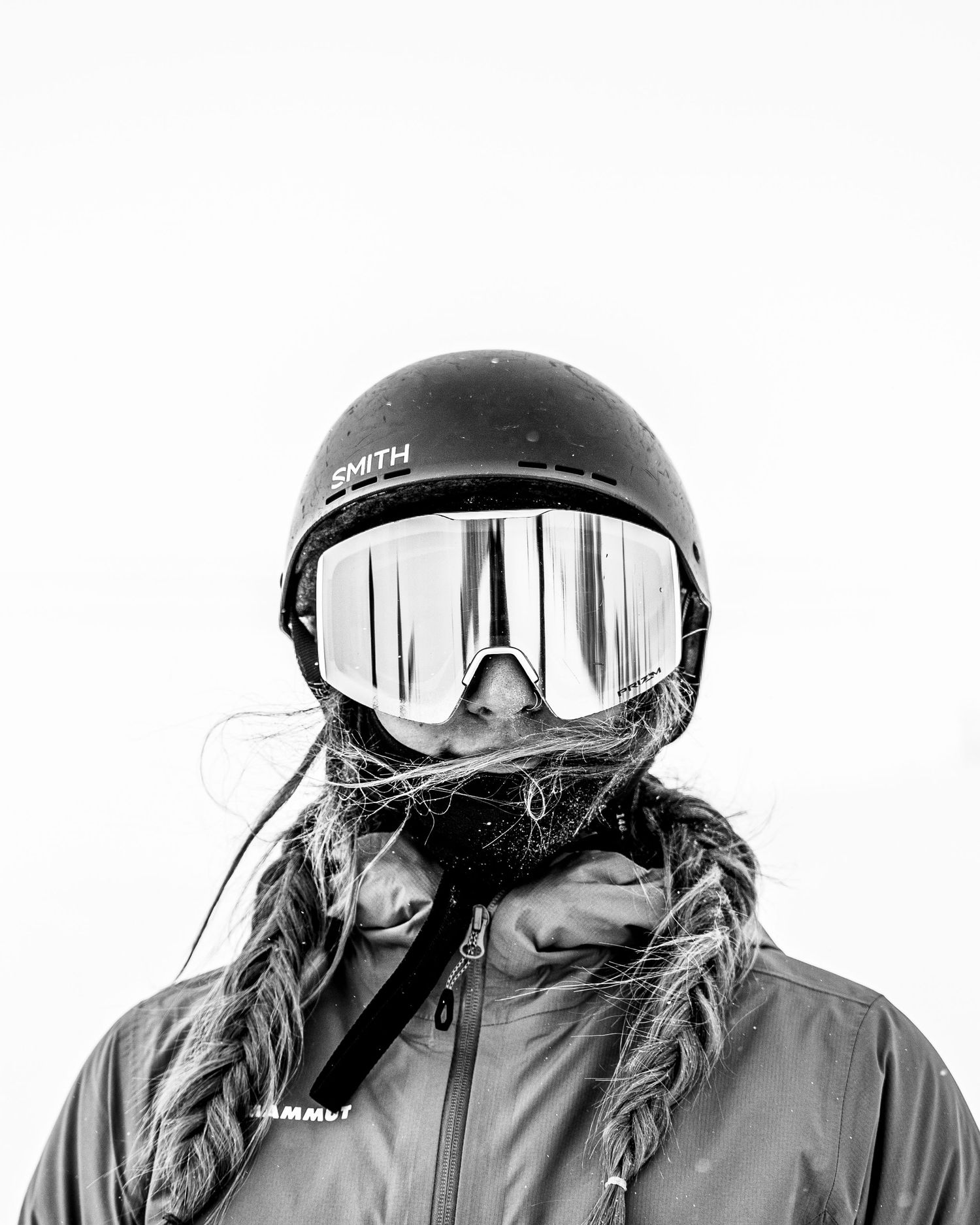 Black ski helmet and goggles against white background in minimalist winter sports portrait.