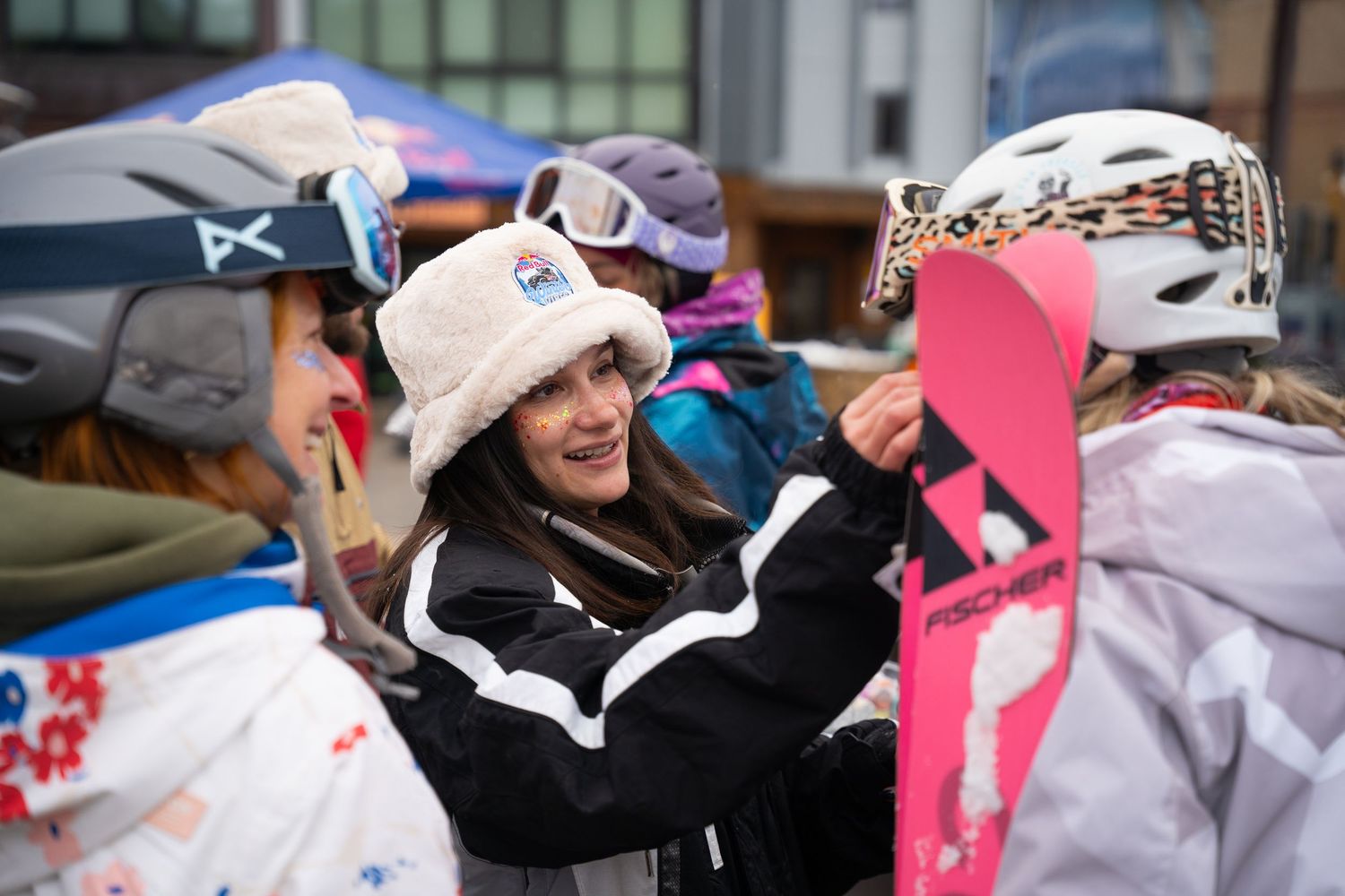 Winter sports enthusiasts gather with gear and equipment at ski resort.