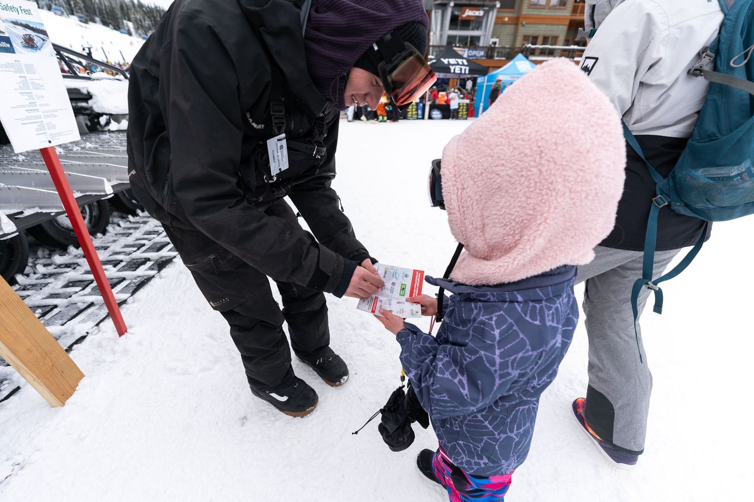 A winter sports safety demonstration taking place in the snow with ski equipment.