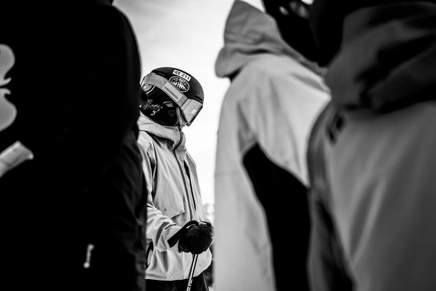 High contrast black and white image of winter sports participants in protective gear.