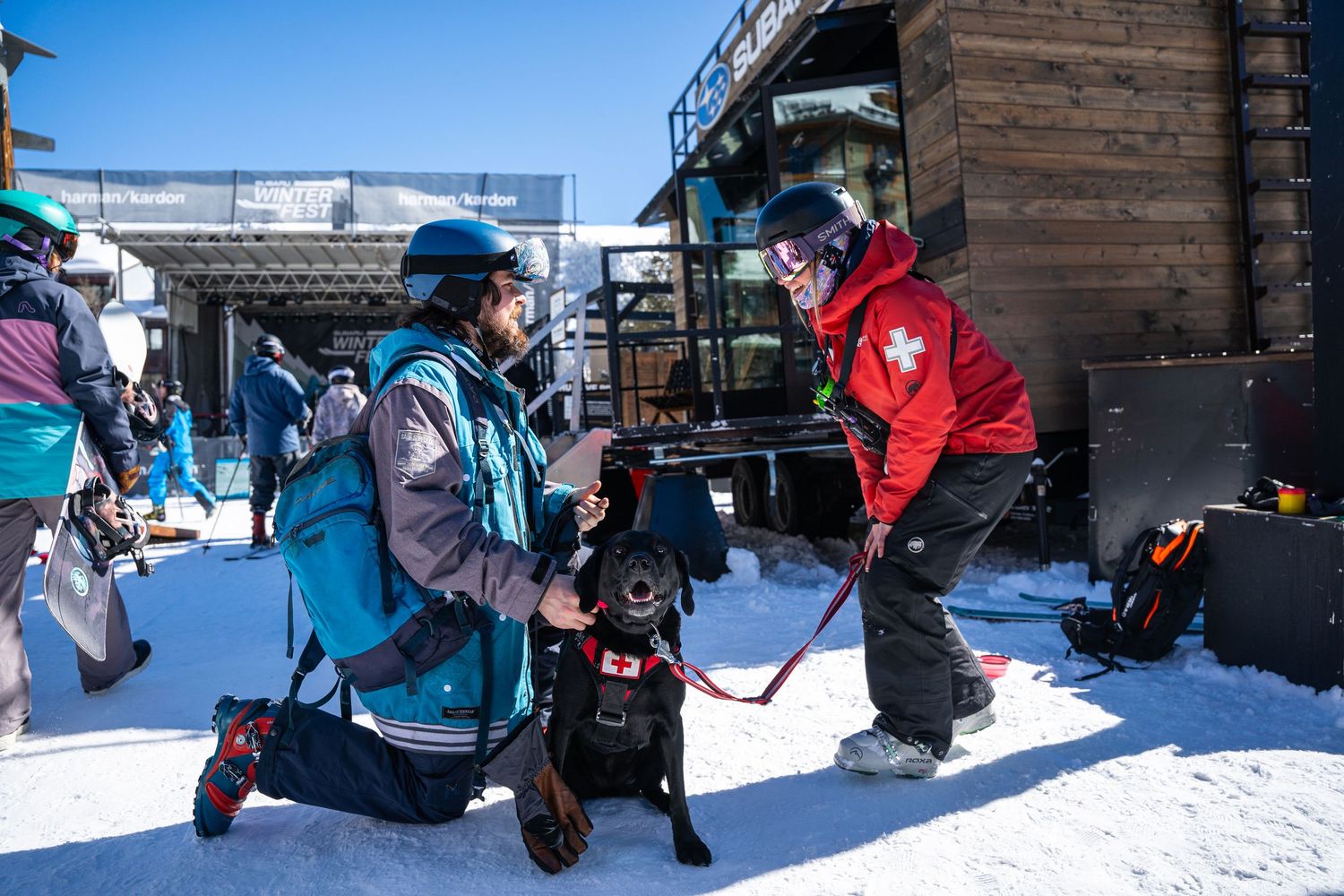 Winter sports instructors demonstrating equipment on snowy slope.
