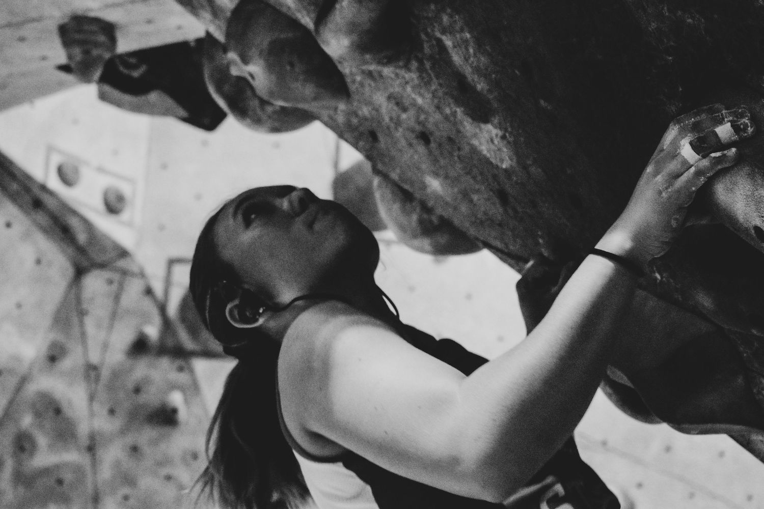 Close-up shot of a climber working their way up an indoor bouldering wall.