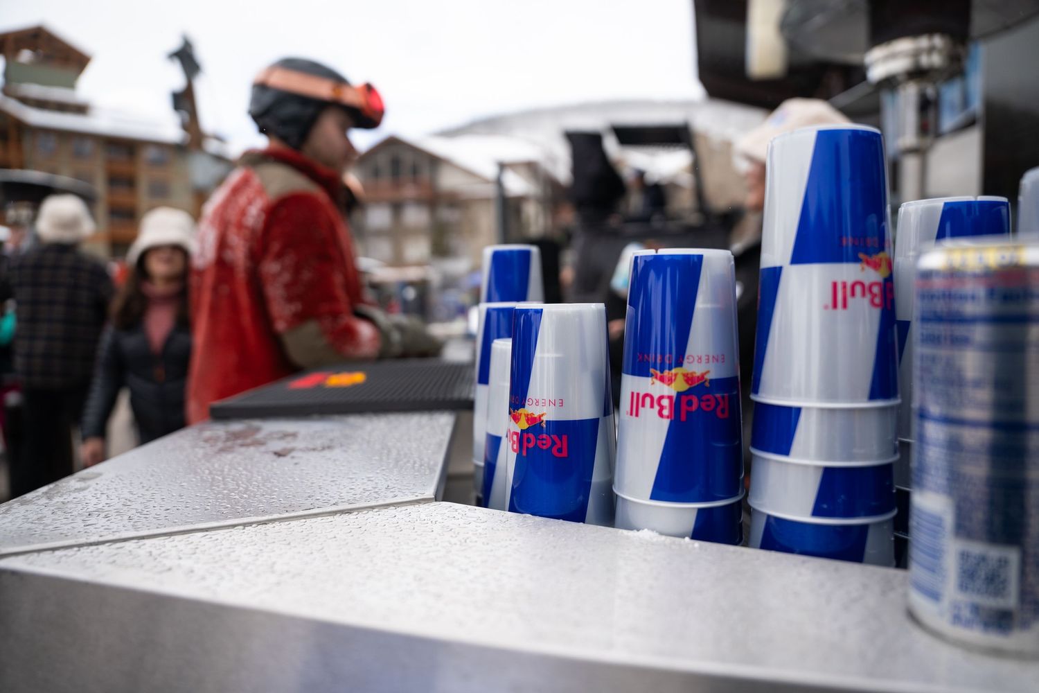Row of Red Bull branded blue and silver cups lined up on counter at ski resort.