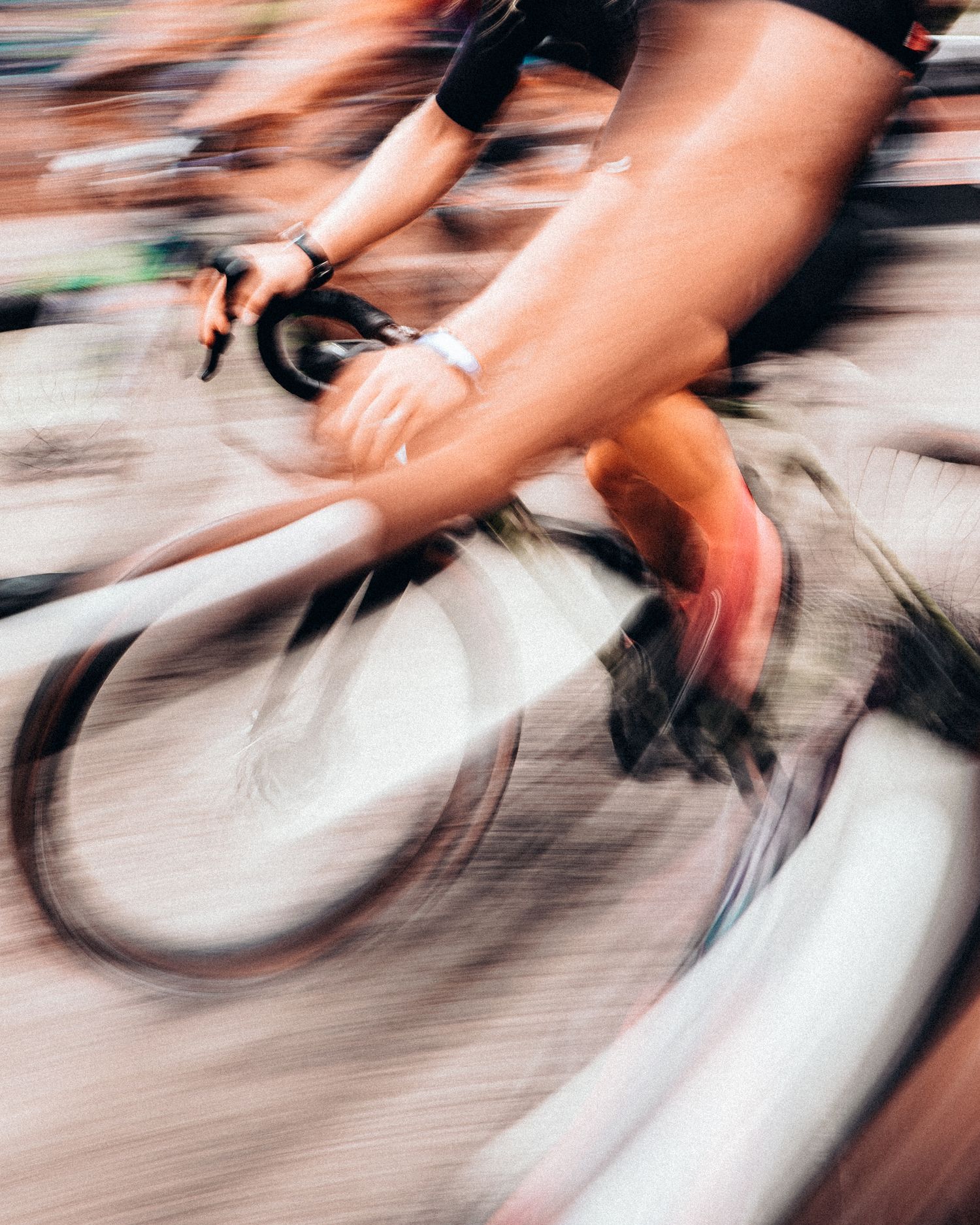 Blurred motion shot of cyclists racing, capturing speed and intensity during a competitive bike race.