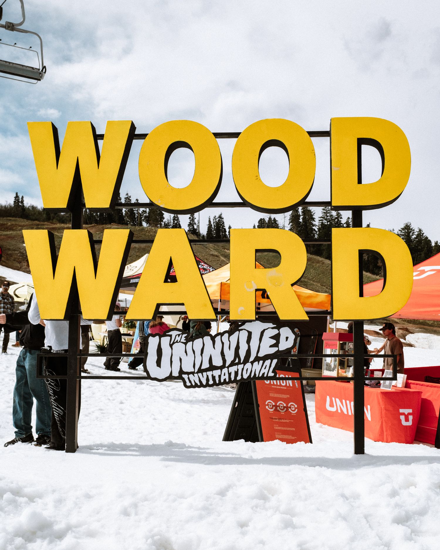 Woodward Uninvited Invitational snowboarding event signage at a snowy mountain resort.