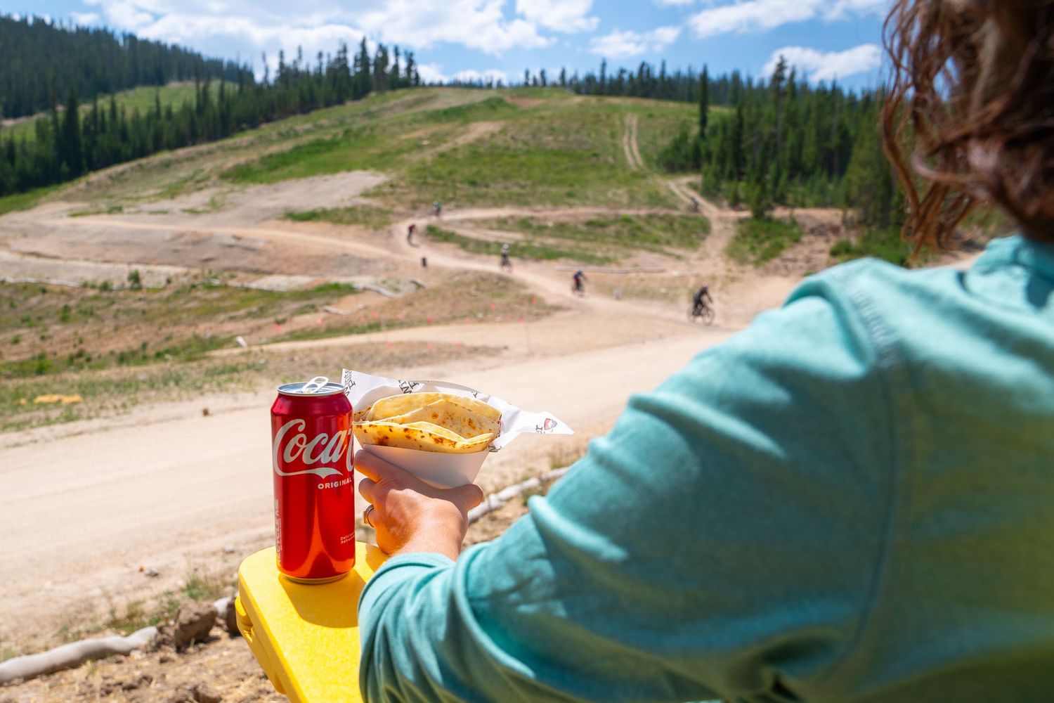 Mountain biking refreshment break with soda and snacks overlooking dirt trails.