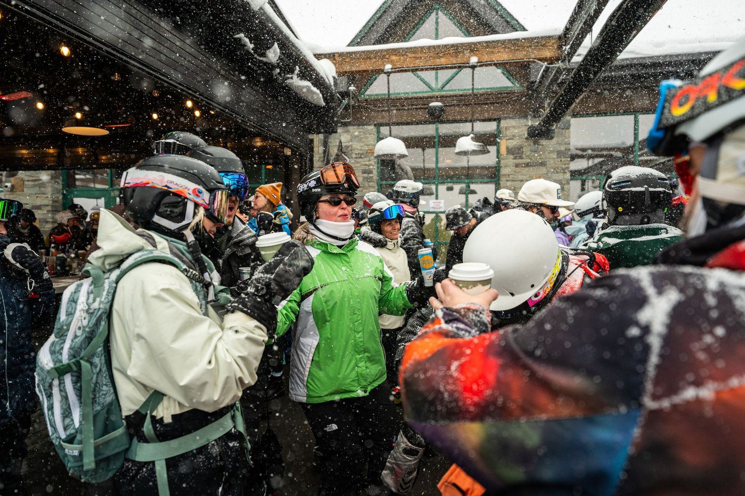 Ski-clad attendees mingling at winter festival during snowfall.