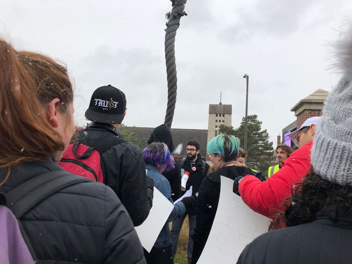 Group of people gathered around a rope during outdoor winter activity.
