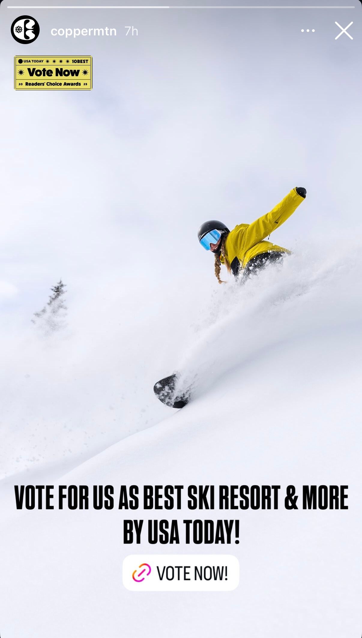 Skier carves through deep powder snow on a steep mountain slope with yellow jacket visible against white terrain.