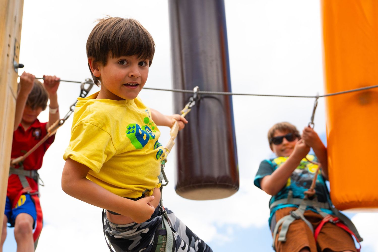 Children enjoy climbing activities at an outdoor adventure park.