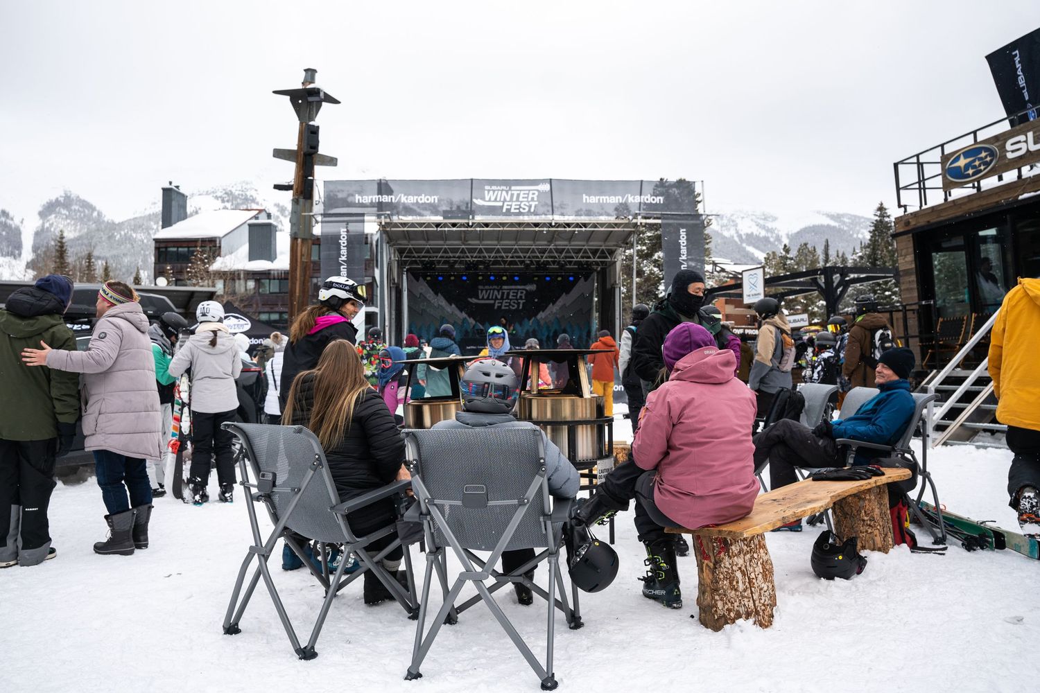 Crowd gathering in chairs watching outdoor winter event performance.
