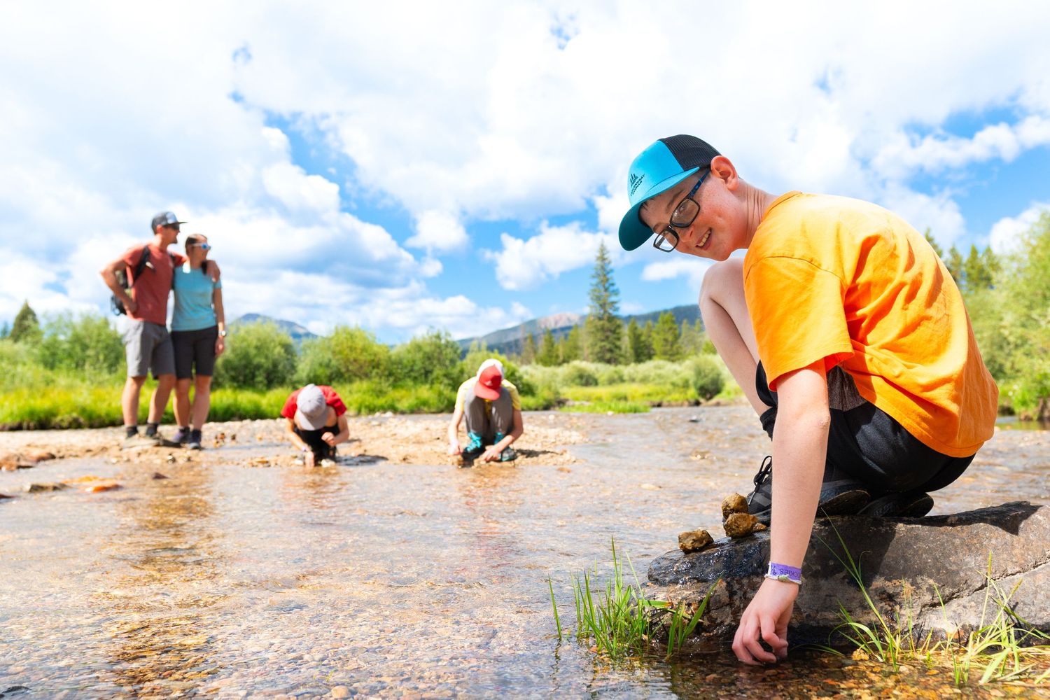 People collecting water from mountain stream during outdoor adventure.