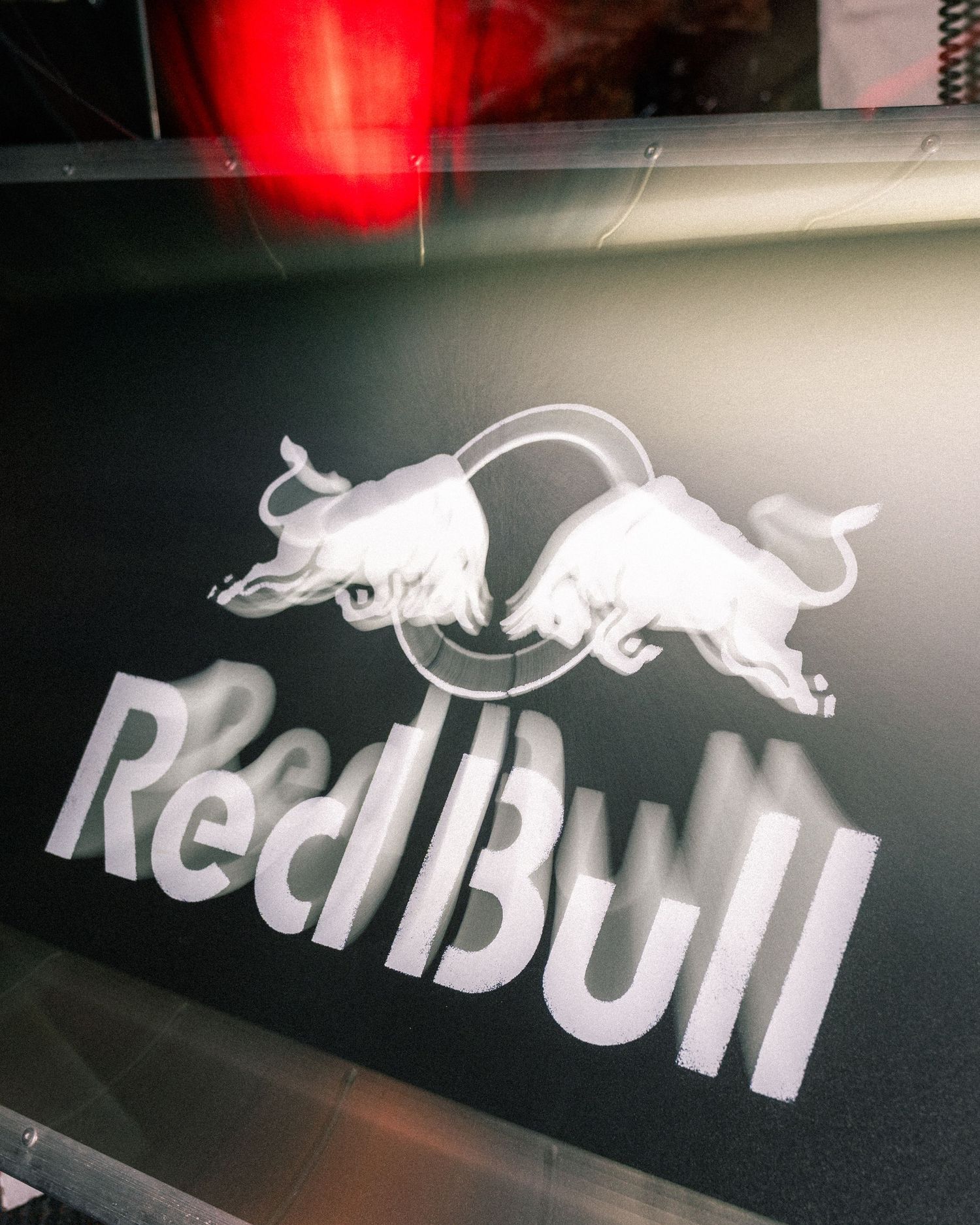 Red Bull logo in silver on a dark background featuring two bulls charging at each other.