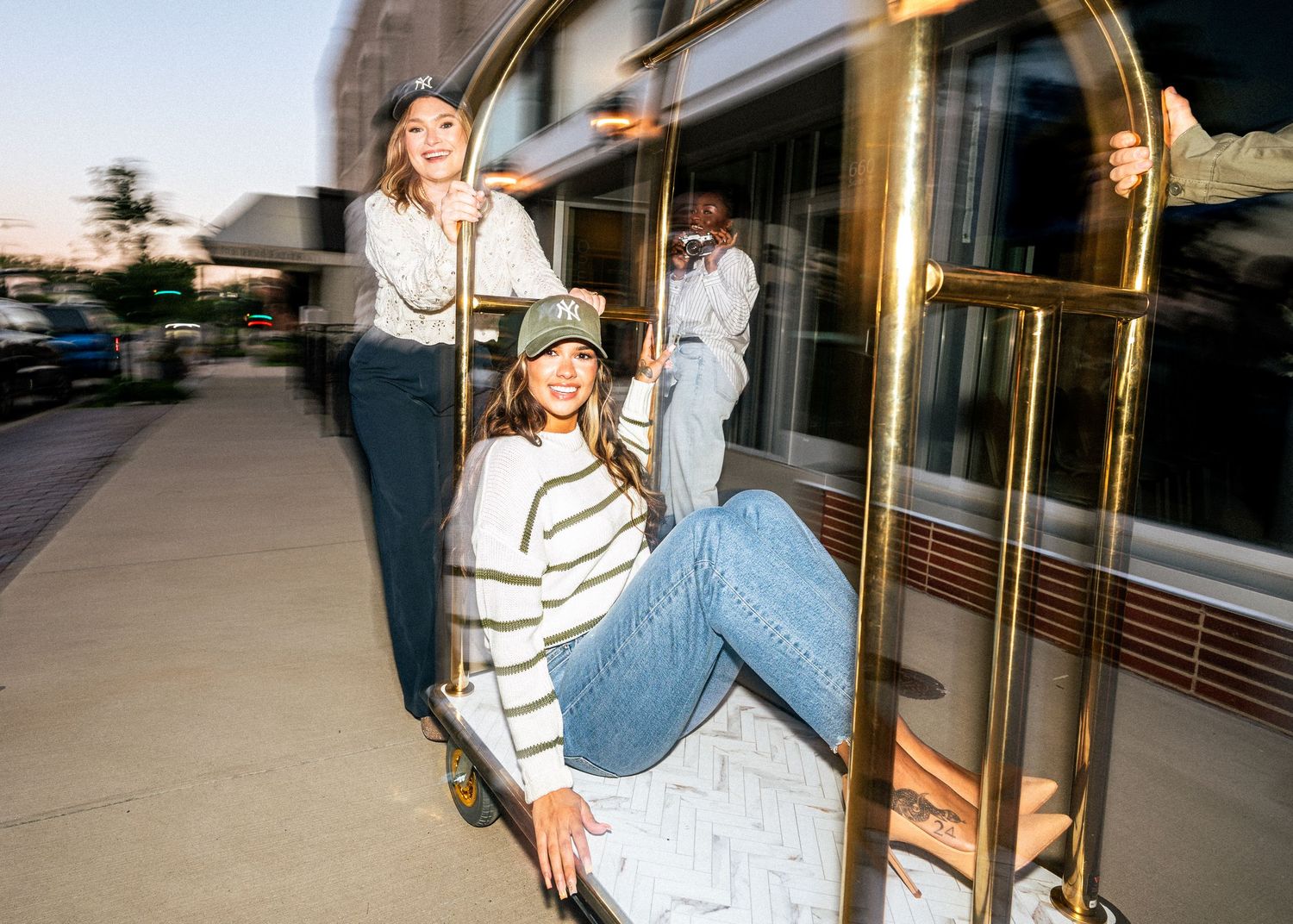 Five sequential shots show someone in jeans and striped shirt sitting and laughing on concrete steps outside a storefront.