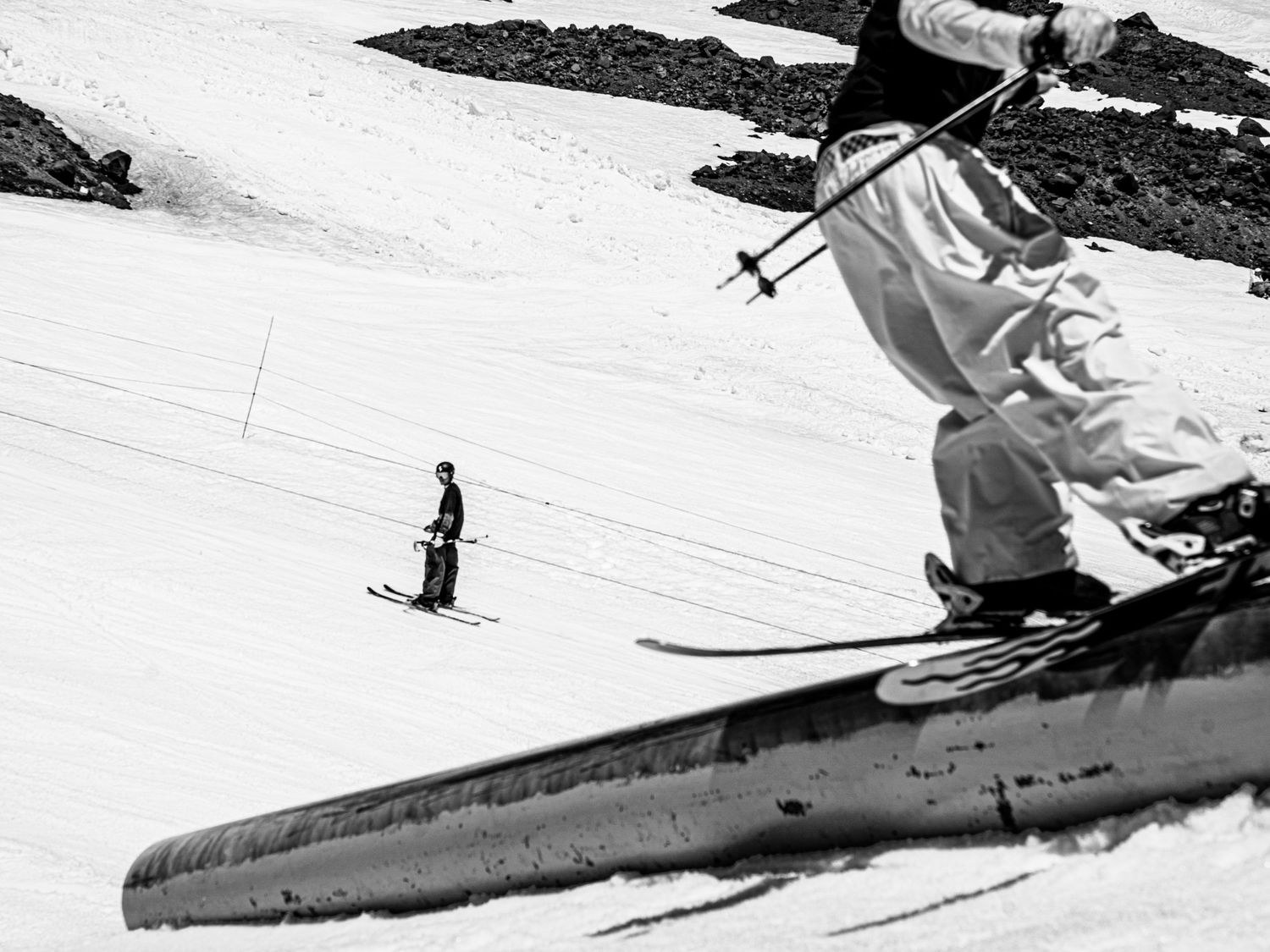 Vintage style photograph of skier jumping off rail in winter terrain park.