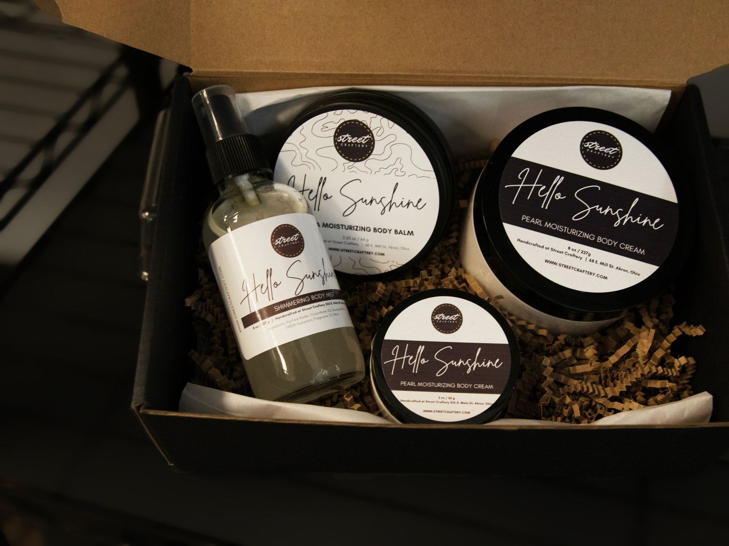 Hello Sunshine gift box set featuring body balm, body cream, and spray products in elegant black and white packaging.
