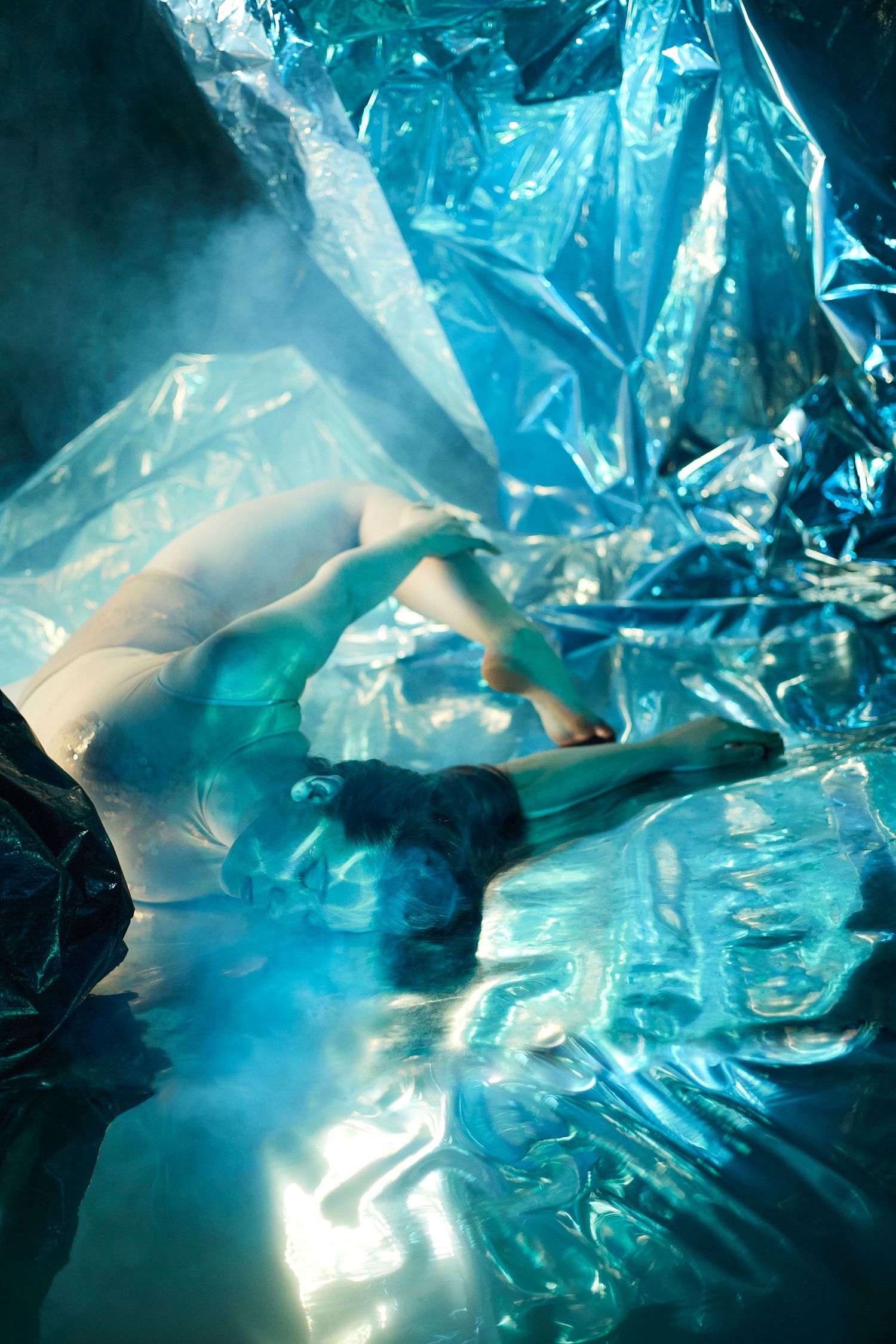 Abstract blue crystal ice cave formations illuminated by sunlight creating ethereal patterns and glowing translucent textures.