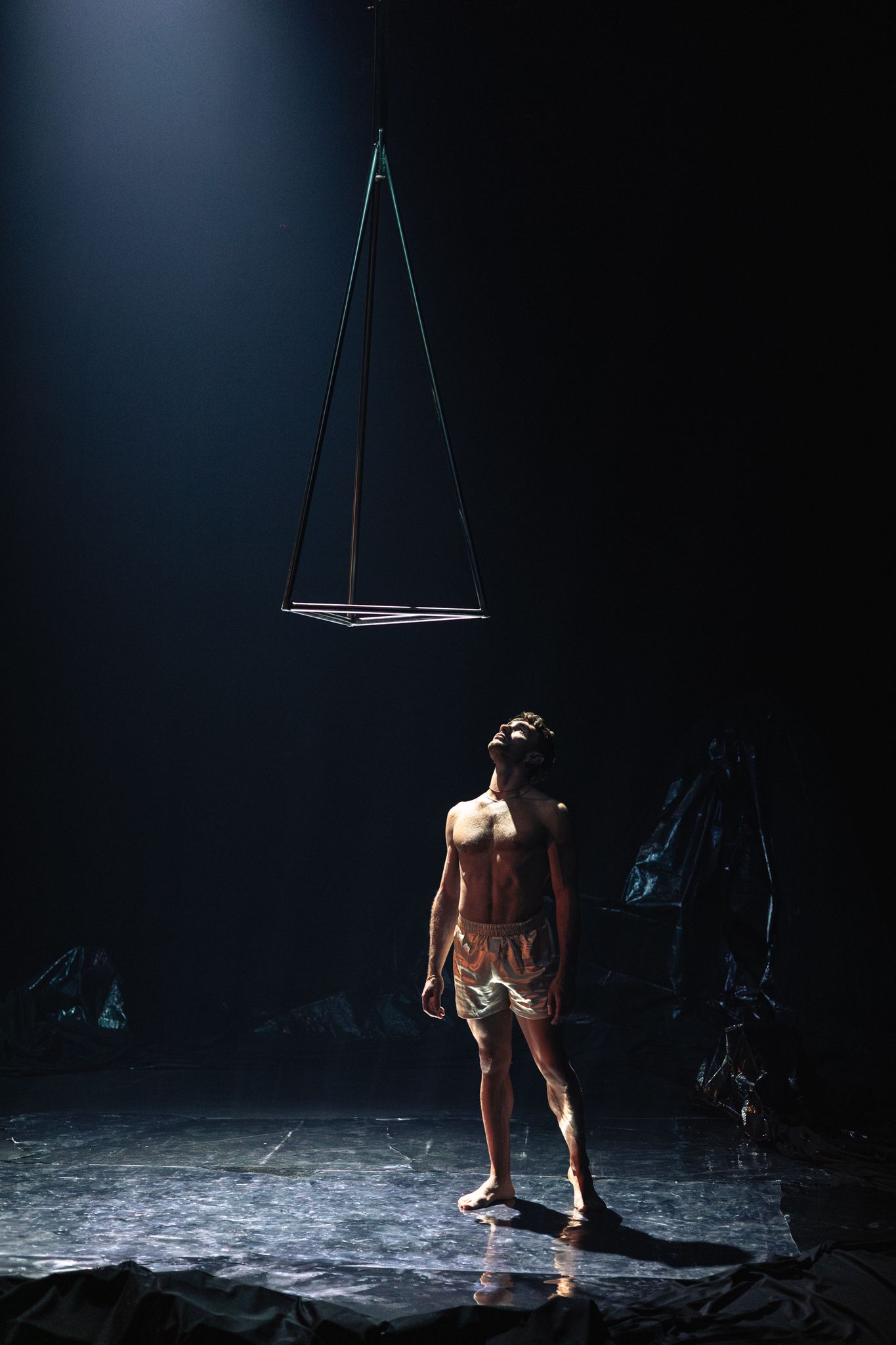 A dramatic aerial dance performance sequence showing a performer in moody lighting against a dark background.