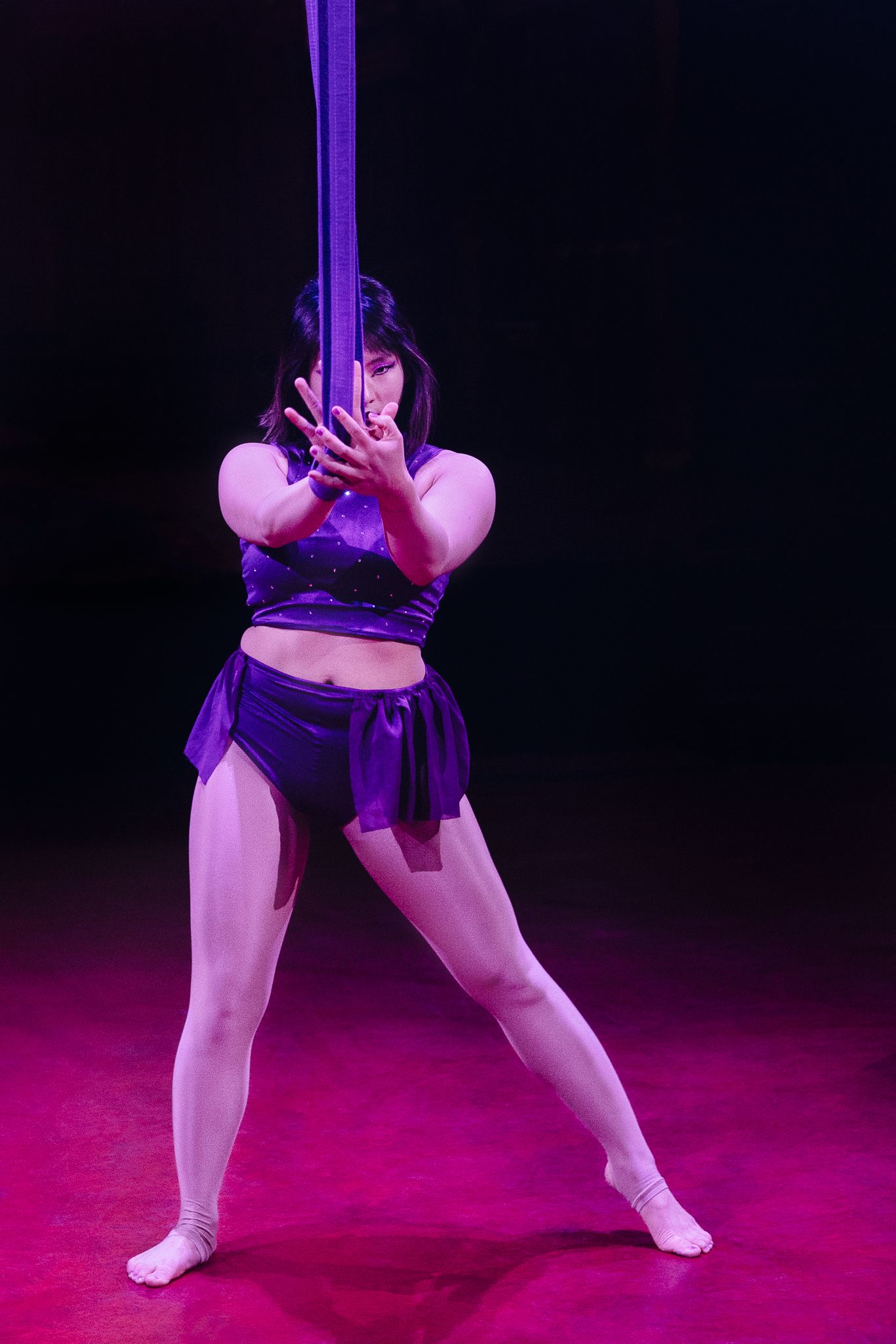 Series of four dance poses showing graceful movement with a purple silk prop against a magenta backdrop.