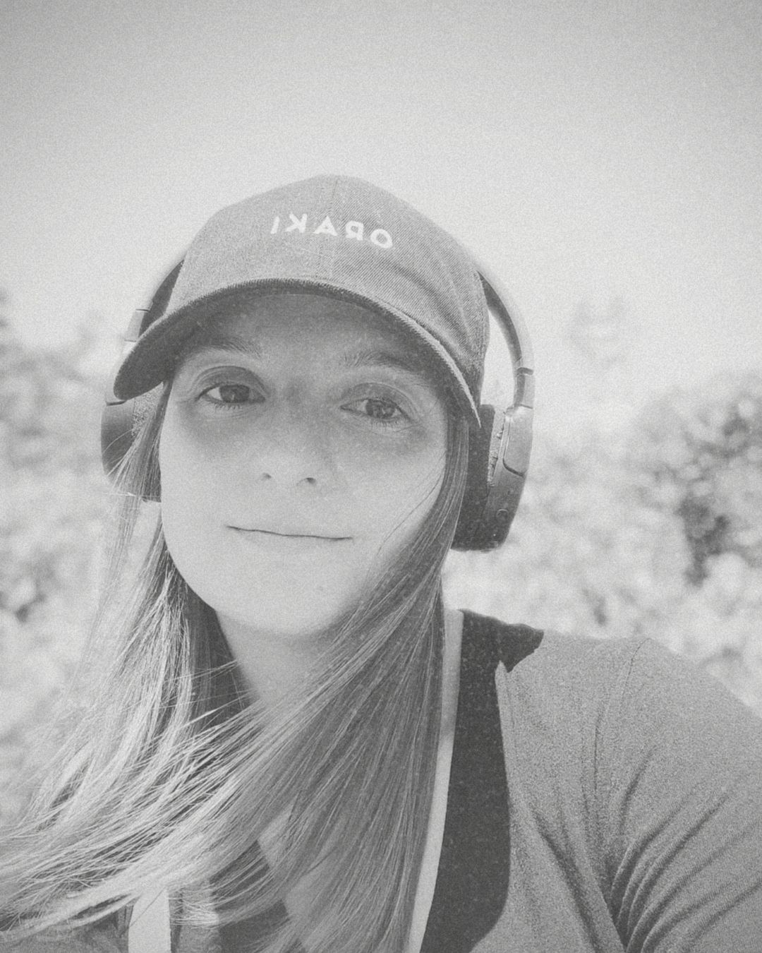 A series of black and white self-portrait style photos showing someone wearing a baseball cap and headphones.